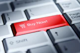 Red 'buy now!' button on a computer keyboard.