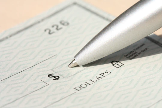 Pen poised over a check, ready to write.