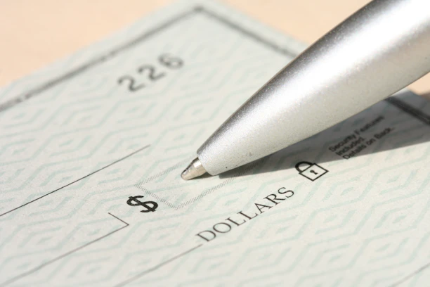 Pen poised over a check, ready to write.