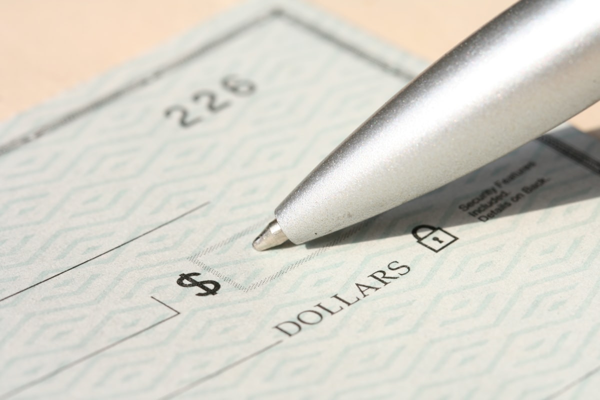 A check being signed for disbursement of recovered surplus funds