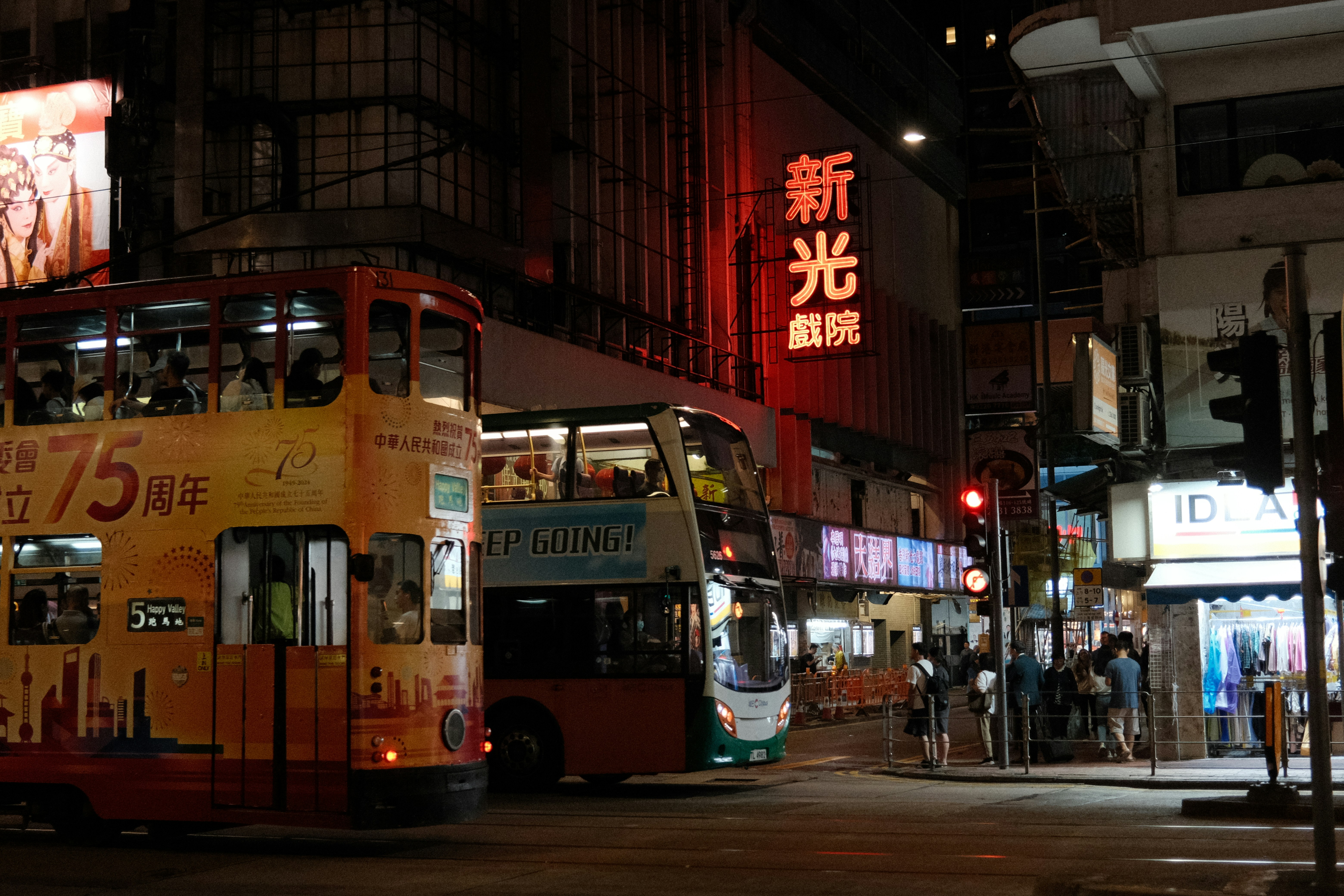 Double-decker buses in a busy city at night