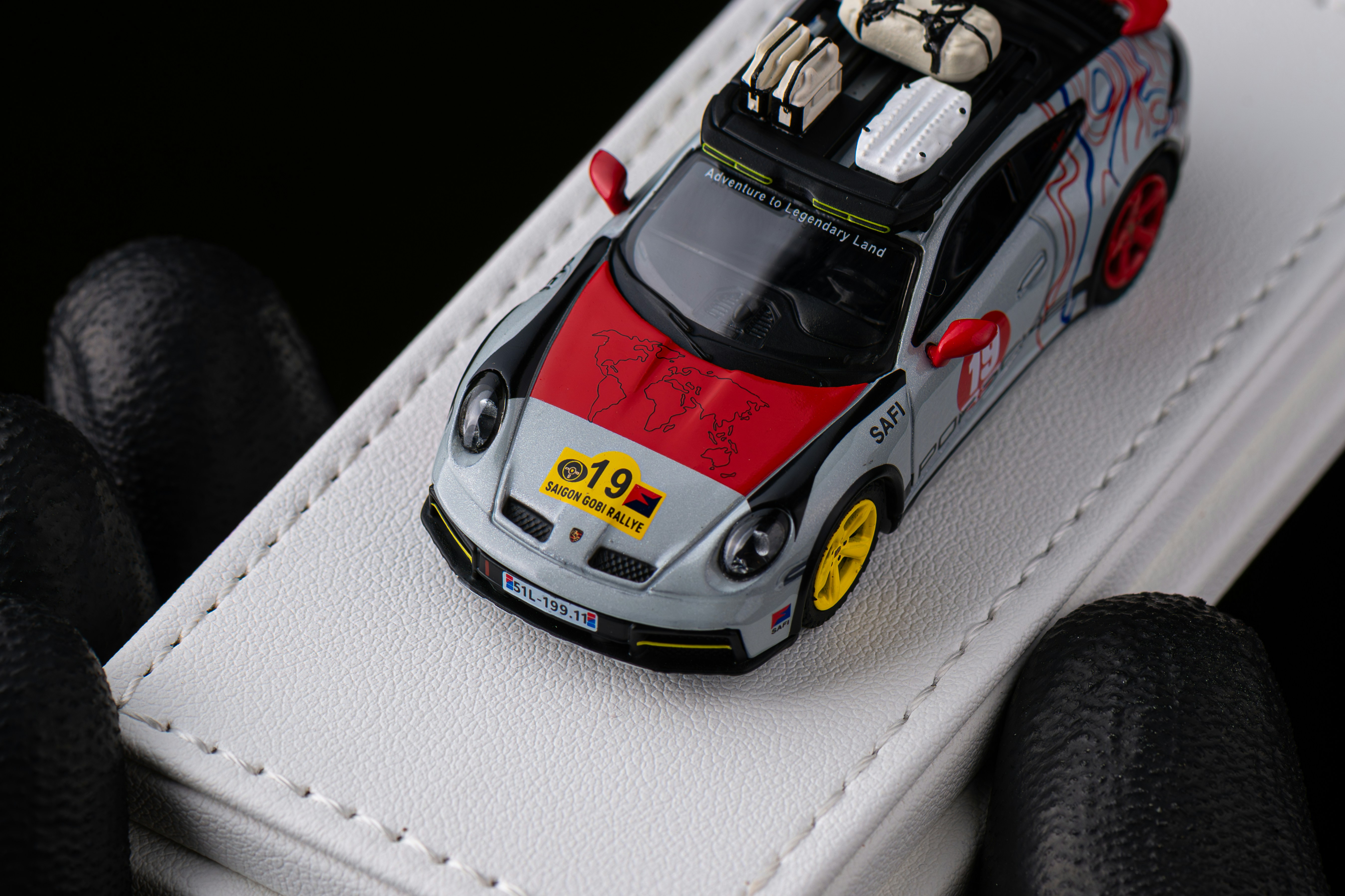 Diecast toy car with rally decals on white surface.
