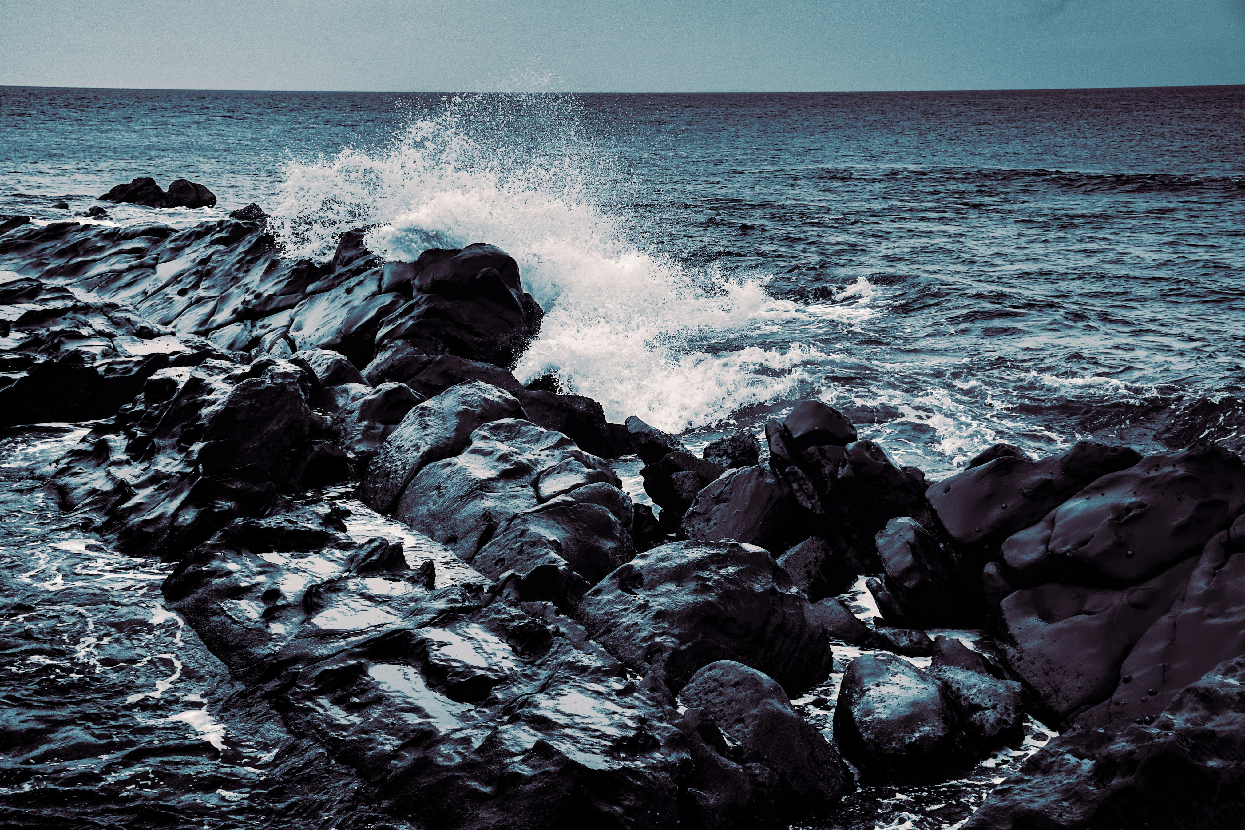 波が暗く岩だらけの岸に打ち寄せる音