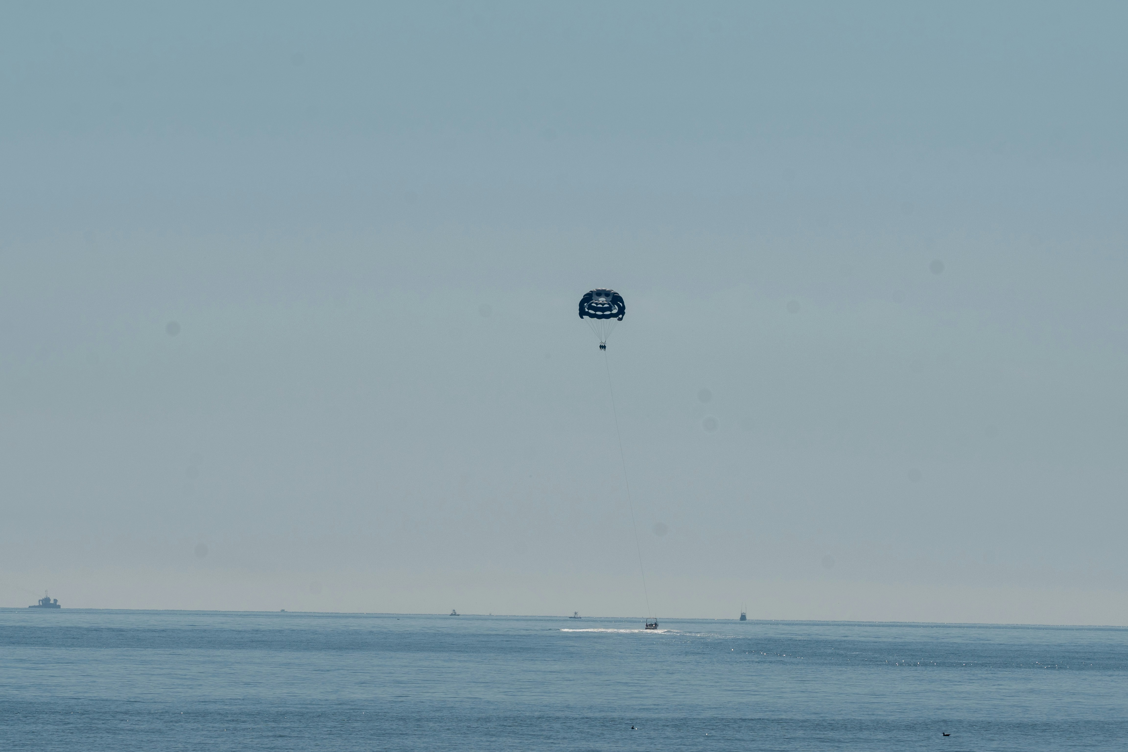 Person parasailing over the calm ocean water