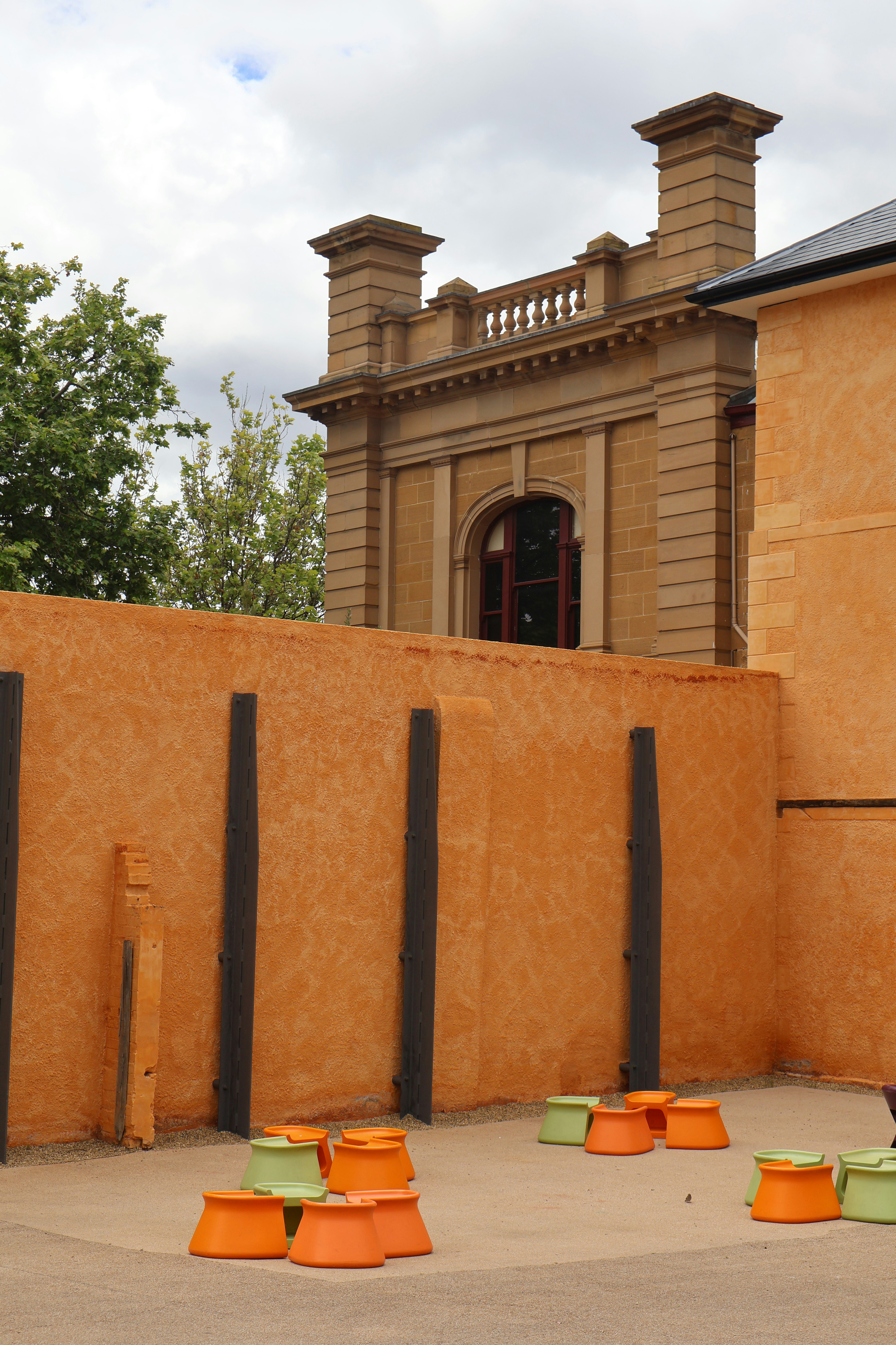Orange and green planters stacked in courtyard