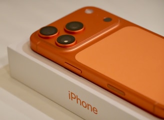 Orange iPhone on its white box packaging