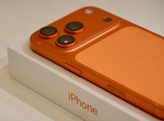 Orange iPhone on its white box packaging