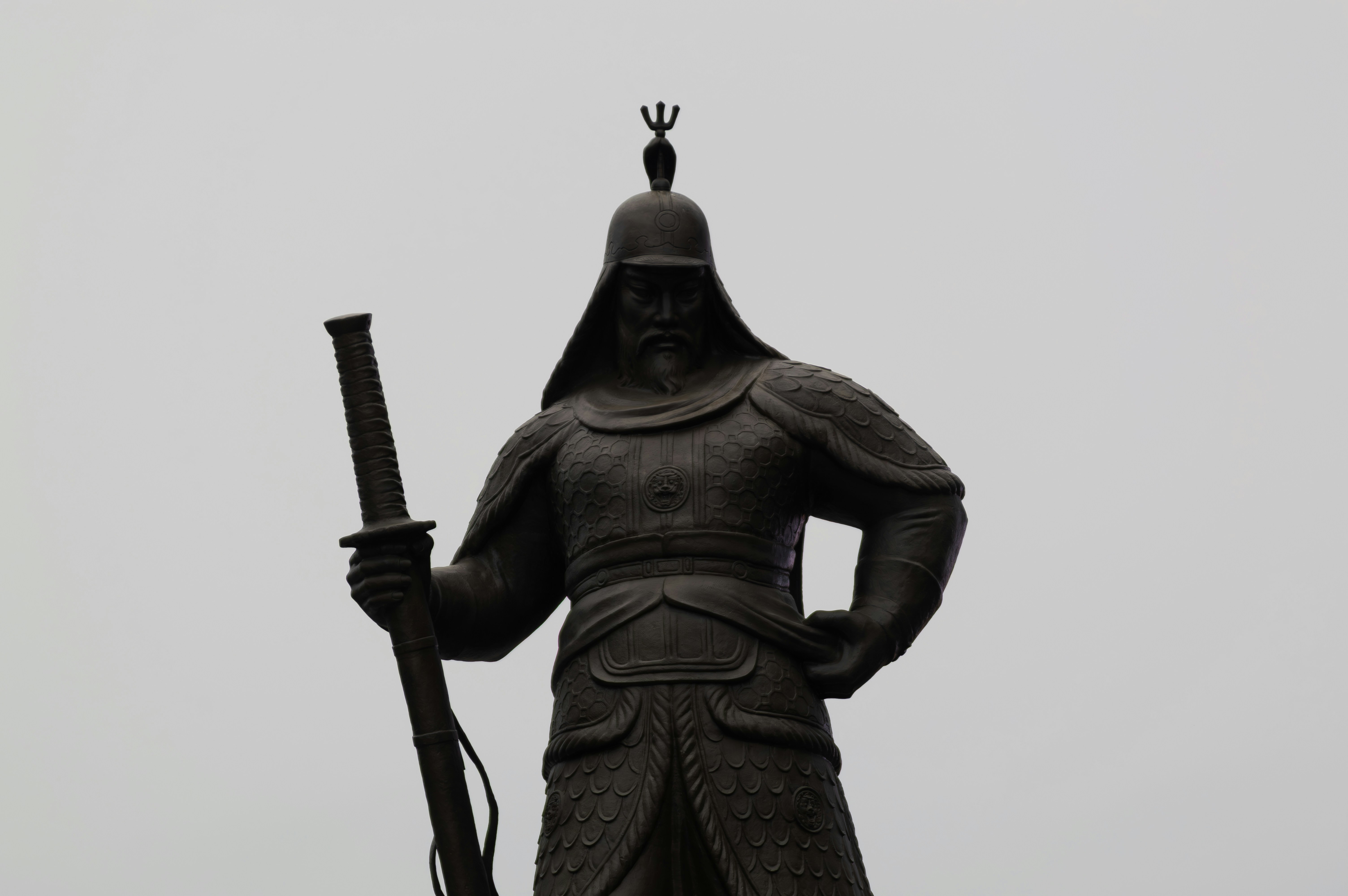 Una oscura estatua de un guerrero empuñando una espada.