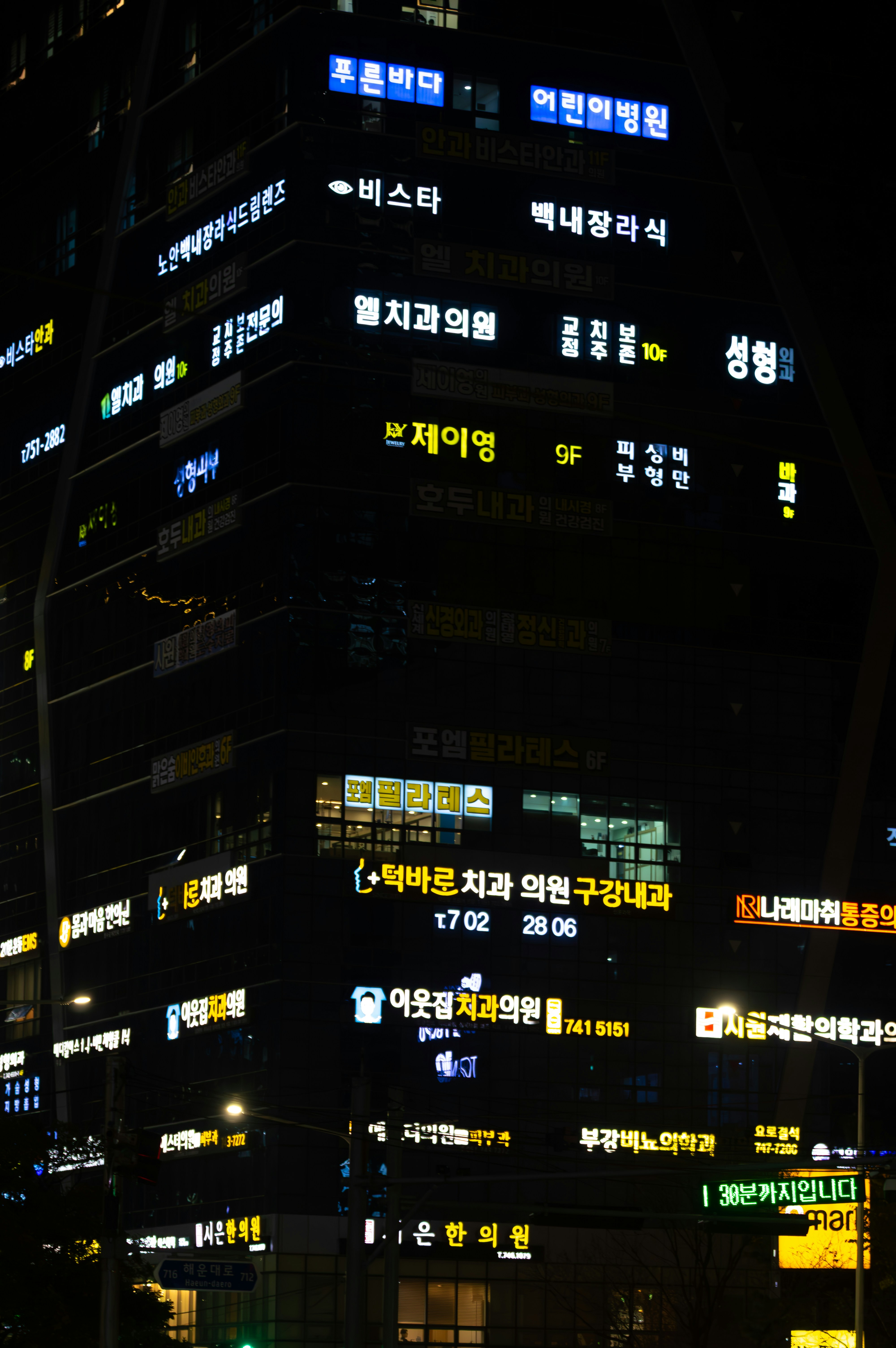 Building with many illuminated signs at night.