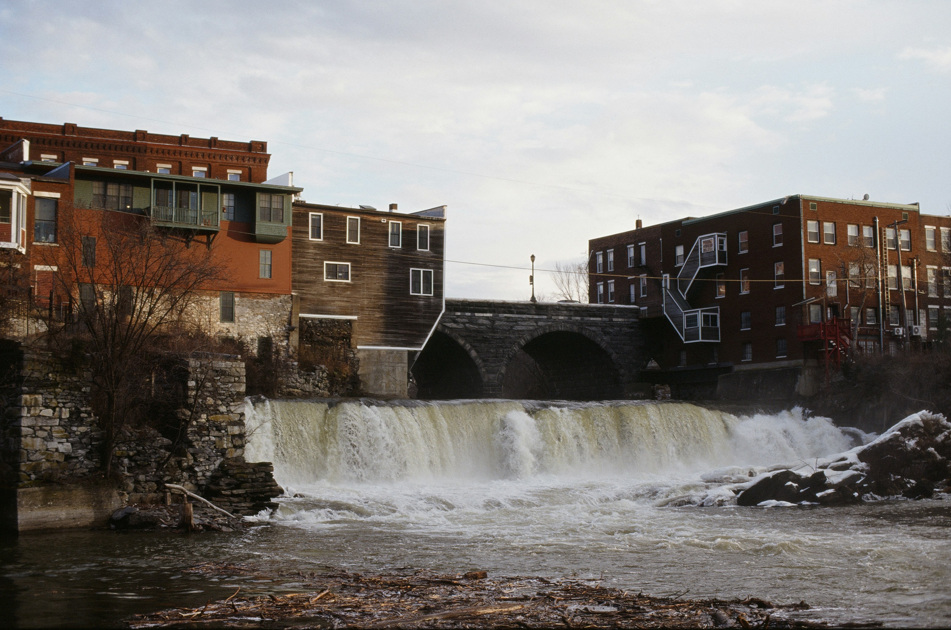 Wasserfall, der zwischen alten Backsteingebäuden stürzt