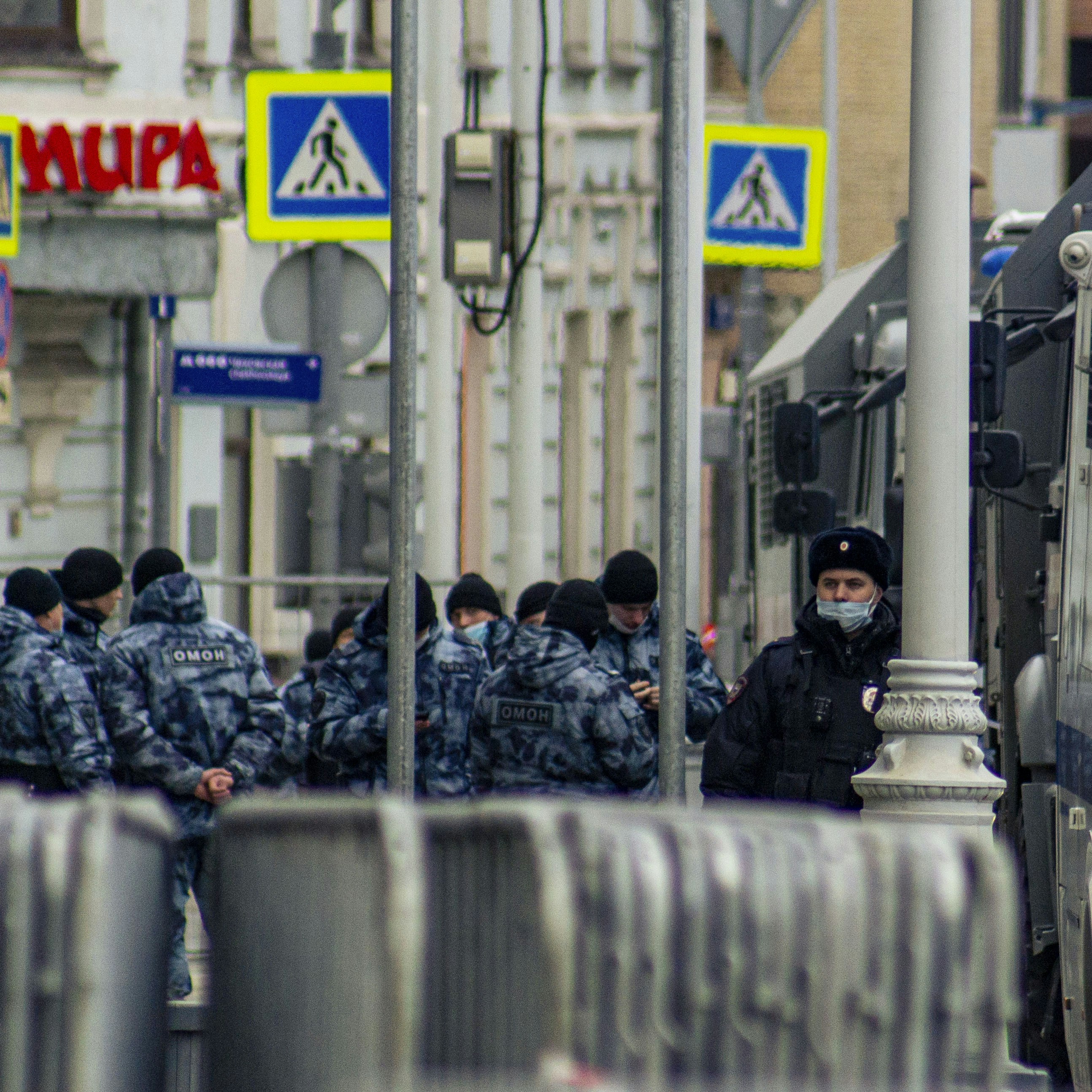 Des policiers en uniforme se tiennent derrière des barrières