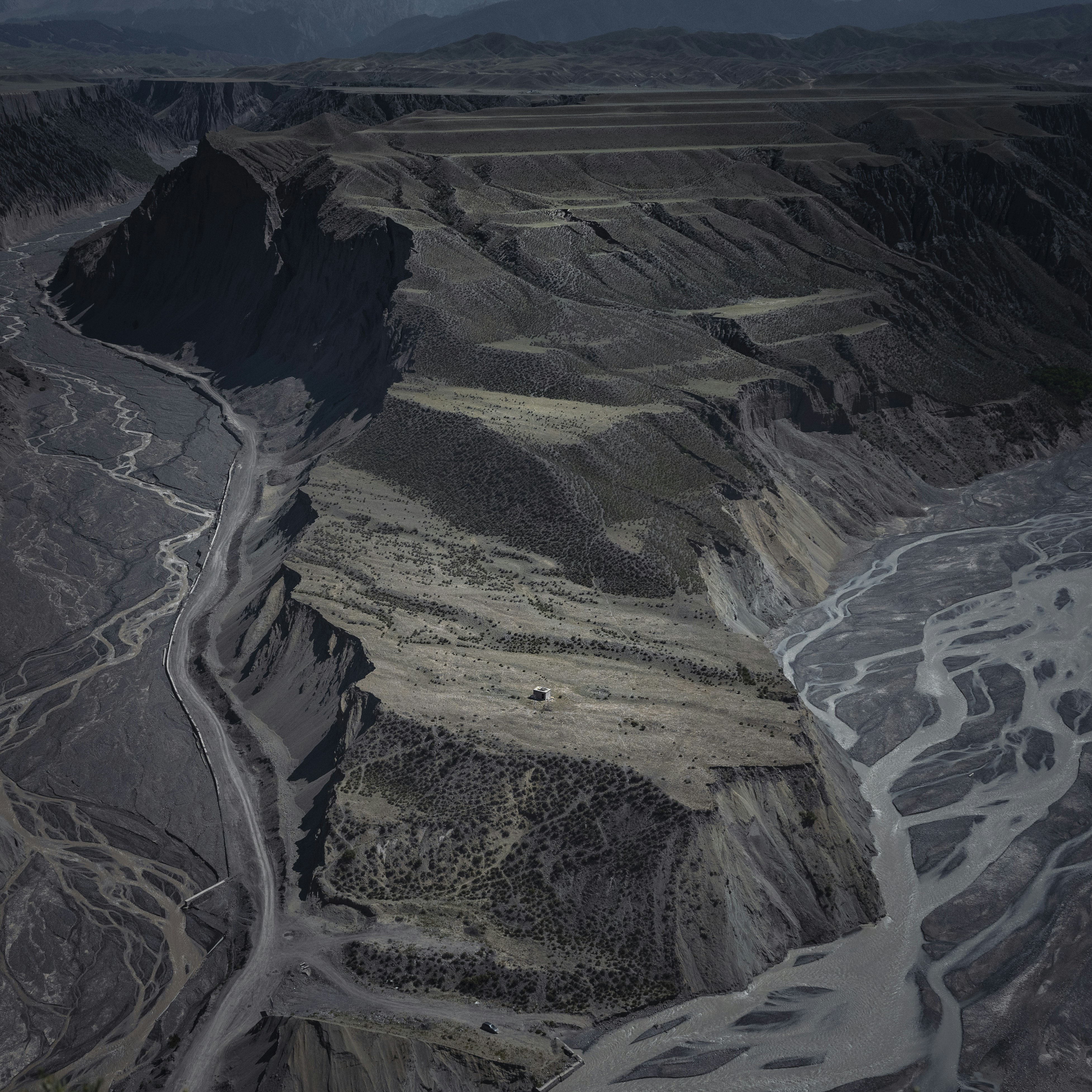 Arid canyon landscape with dry riverbeds and winding roads.