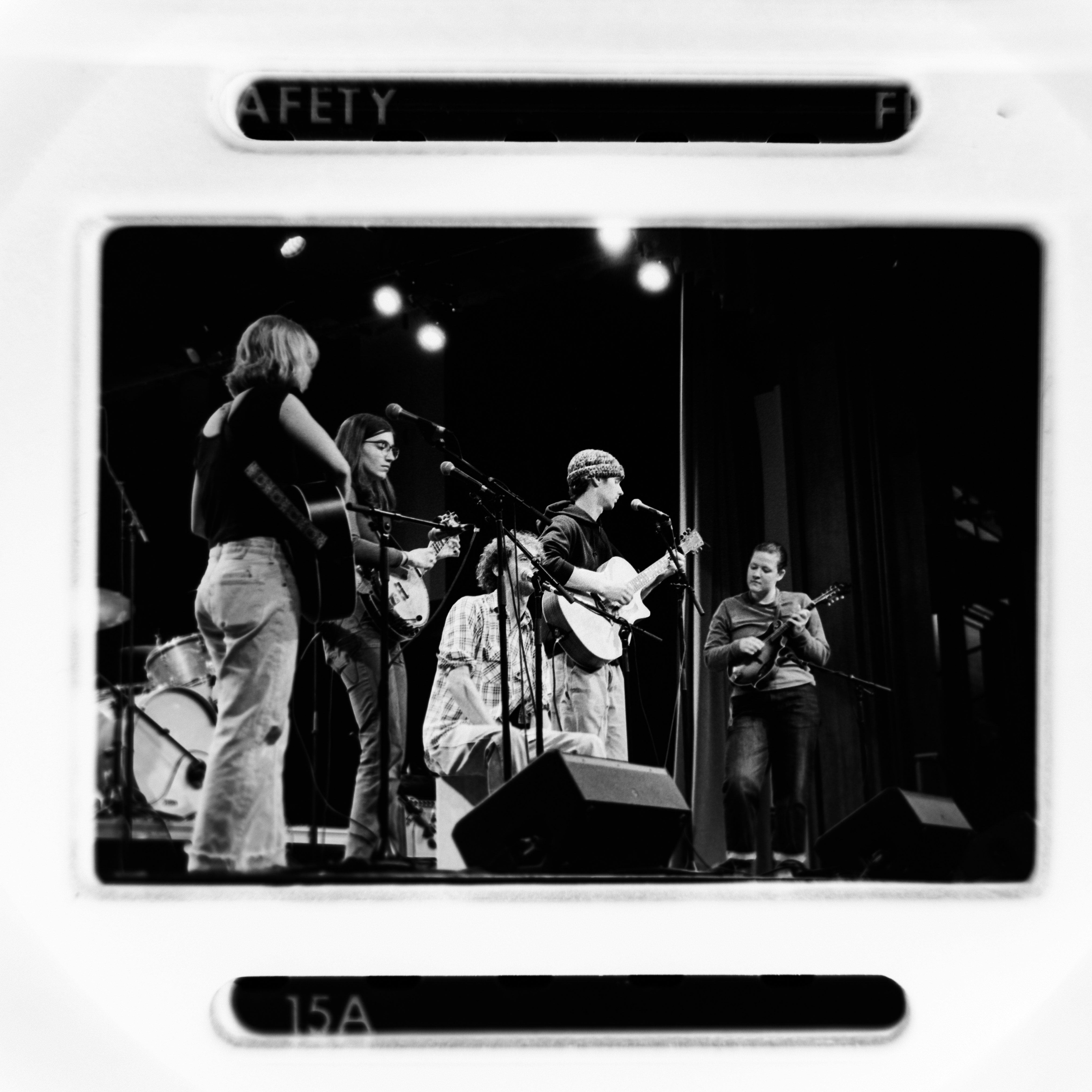 A band performs on stage with instruments.