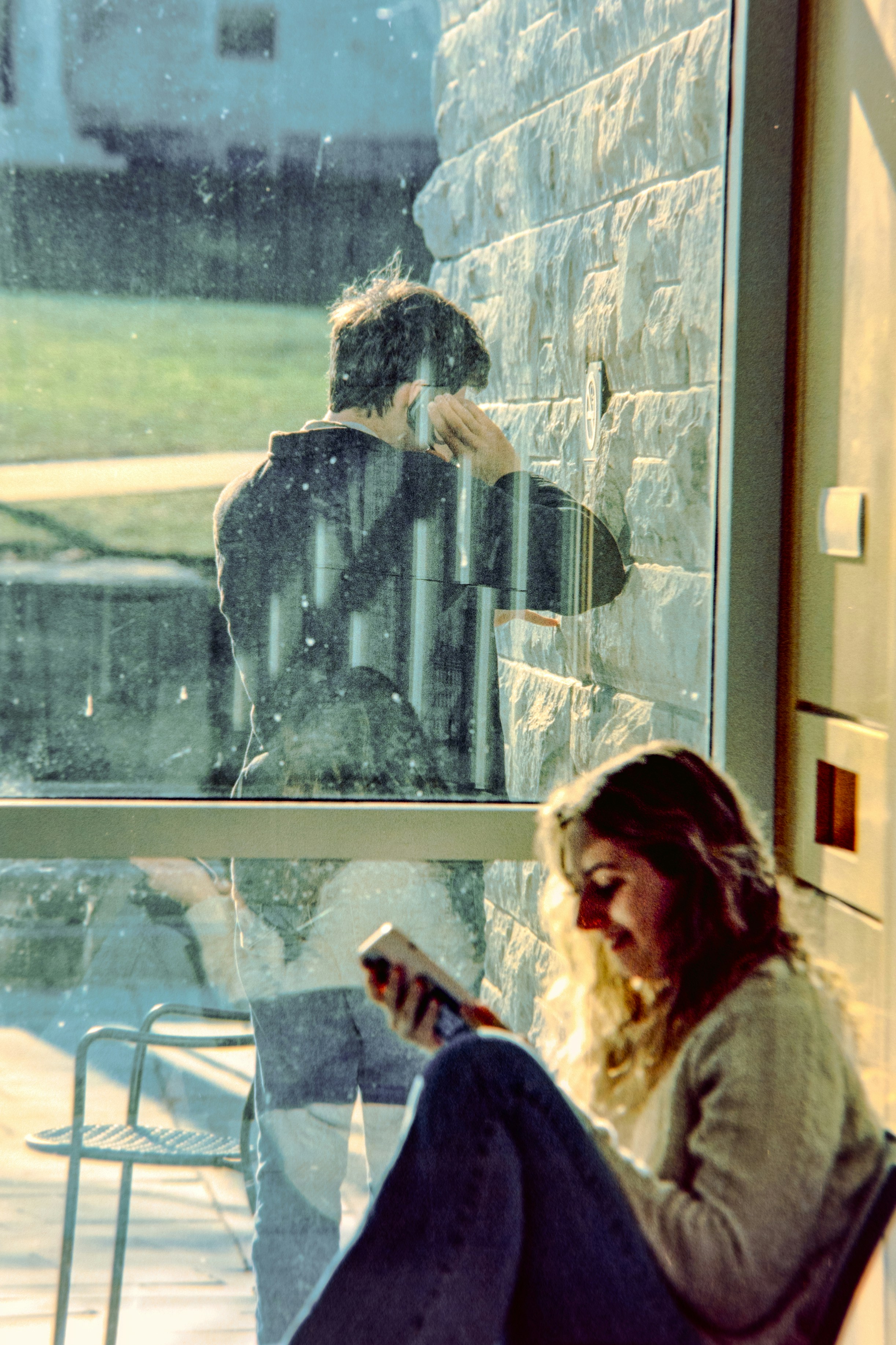 Woman reading book near man on phone