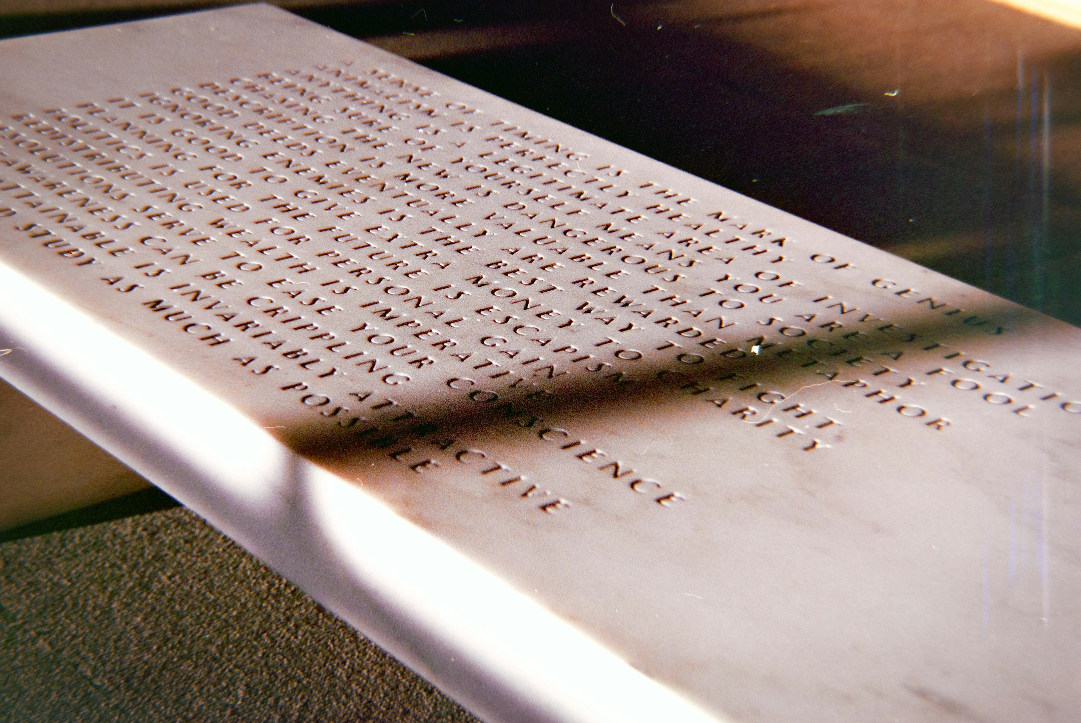 Engraved text on a stone surface in sunlight