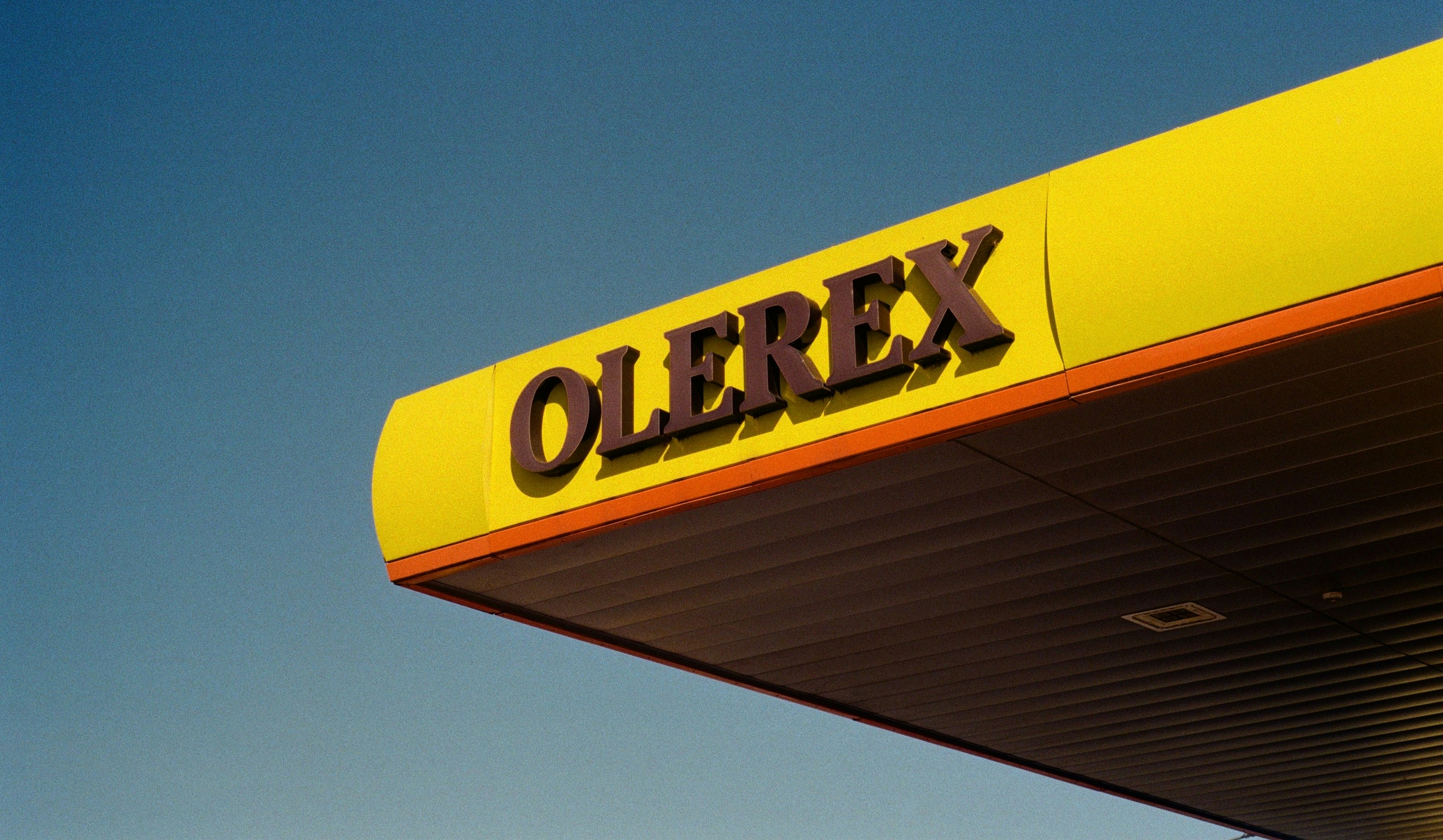 Olerex sign on a yellow canopy against blue sky