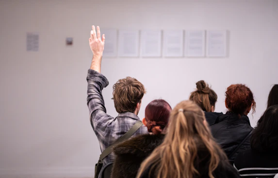 Person raising hand to ask a question