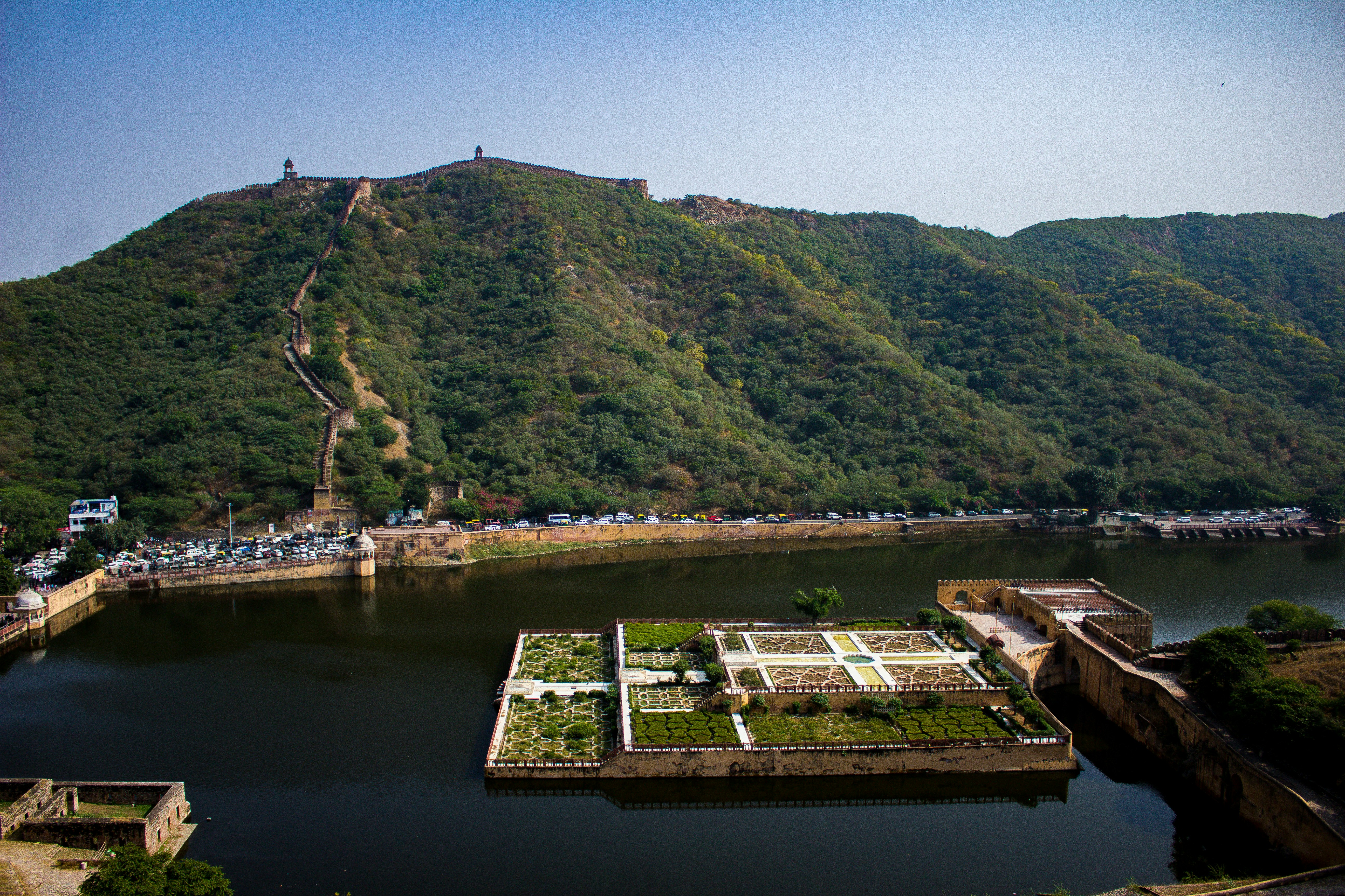 Fortaleza en una colina con vistas a un lago y un jardín