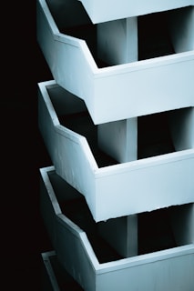 Abstract view of stacked white staircases against dark background
