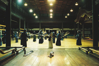 Kendo practitioners in full bogu armor training inside a traditional dojo.