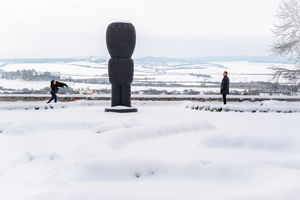 Two people next to a large snow sculpture