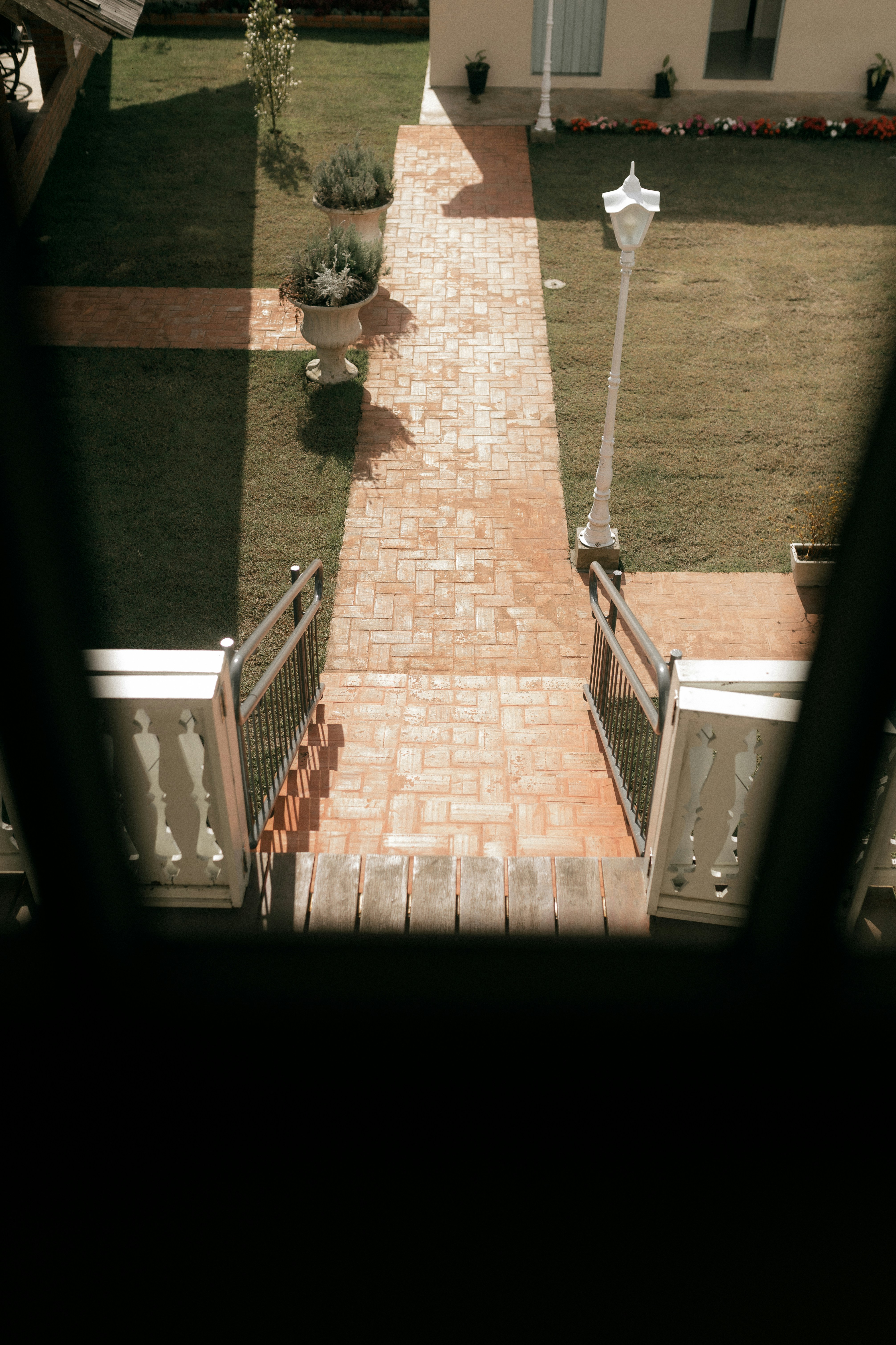Brick pathway leads through a manicured garden.