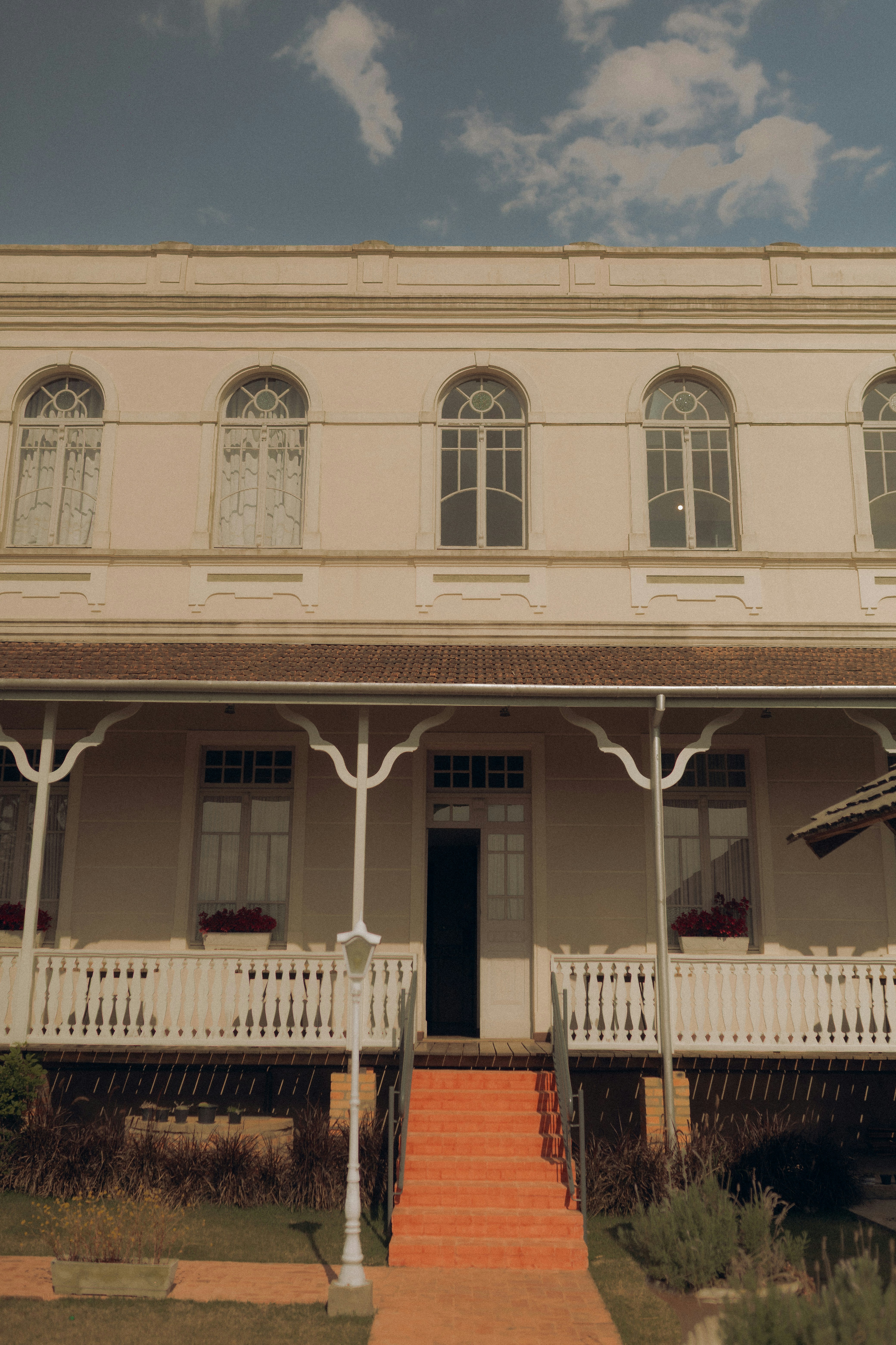 A white colonial house with a porch and stairs.