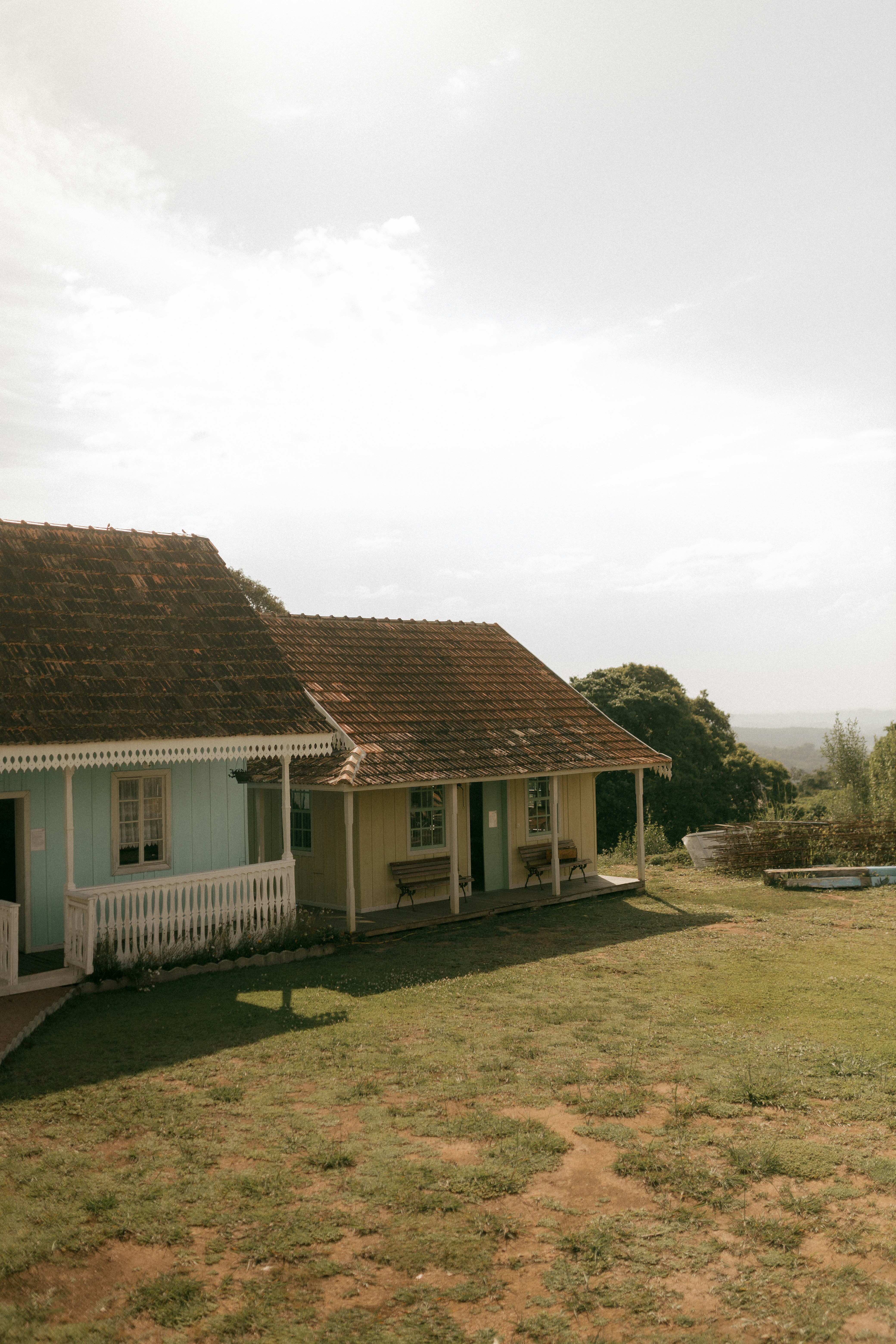 Two colorful houses on a grassy hill.