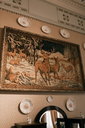Tapestry depicting deer in a snowy forest hangs on wall.