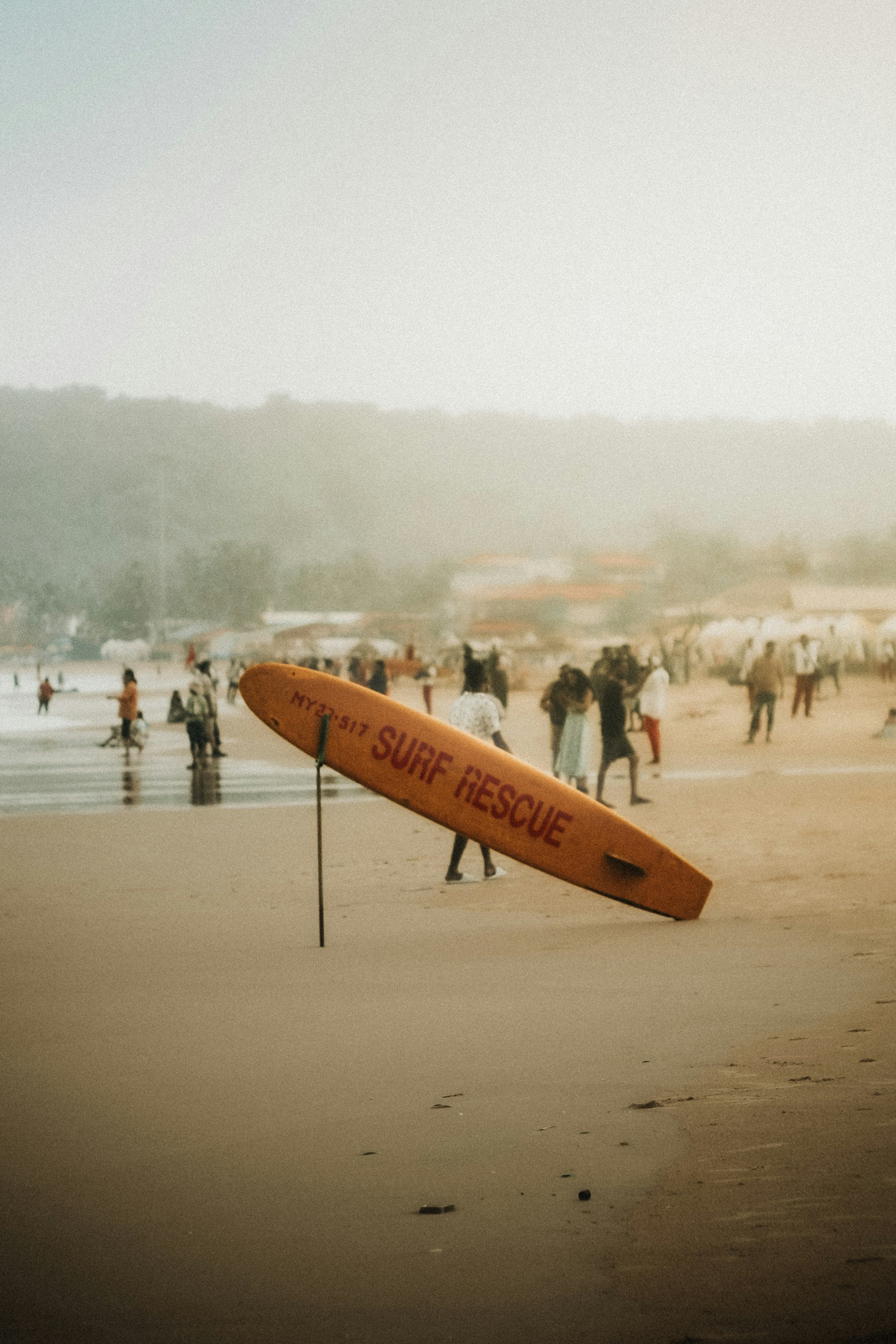 Orange surf rescue board on a sandy beach.