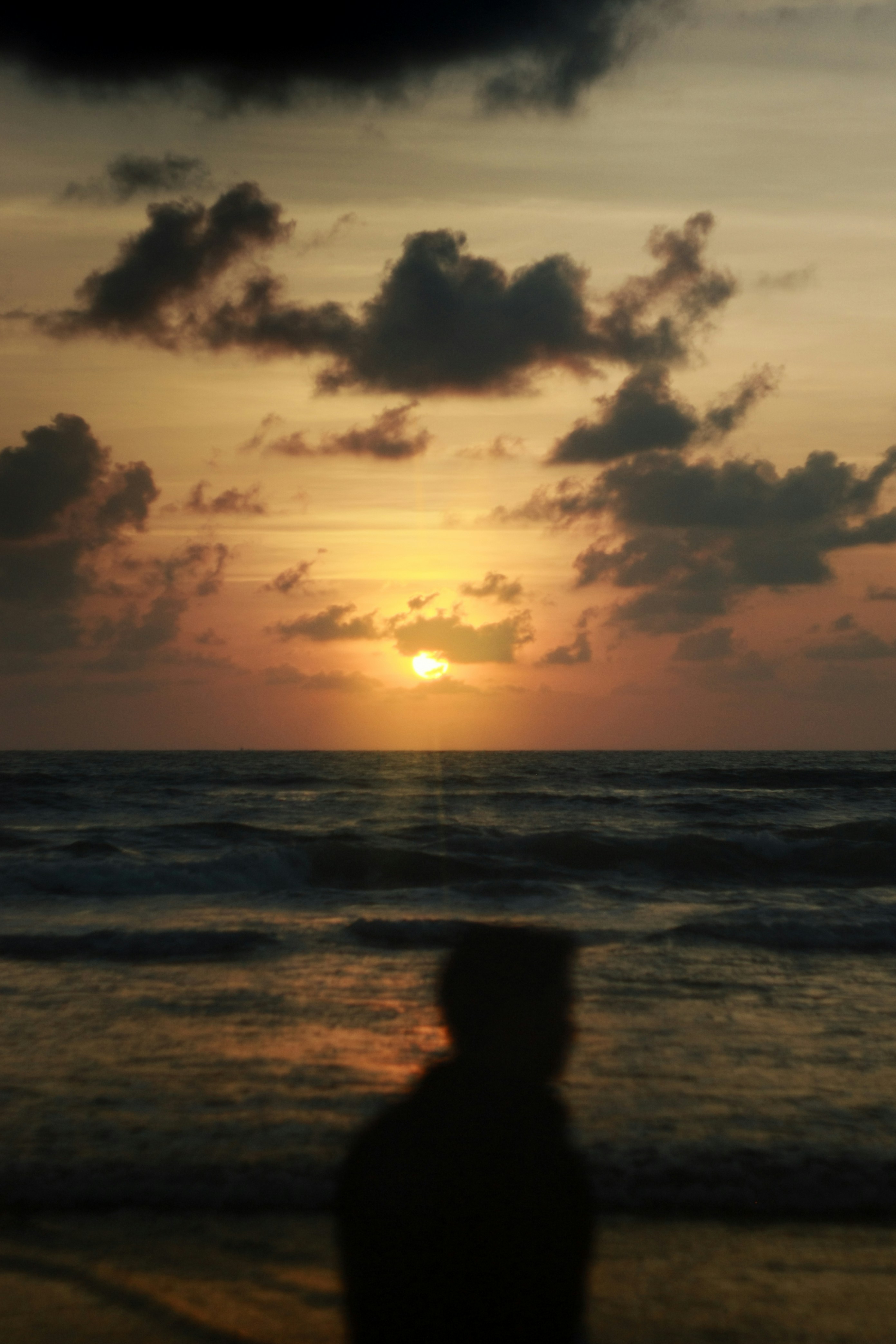 Silhouette of person watching sunset over the ocean
