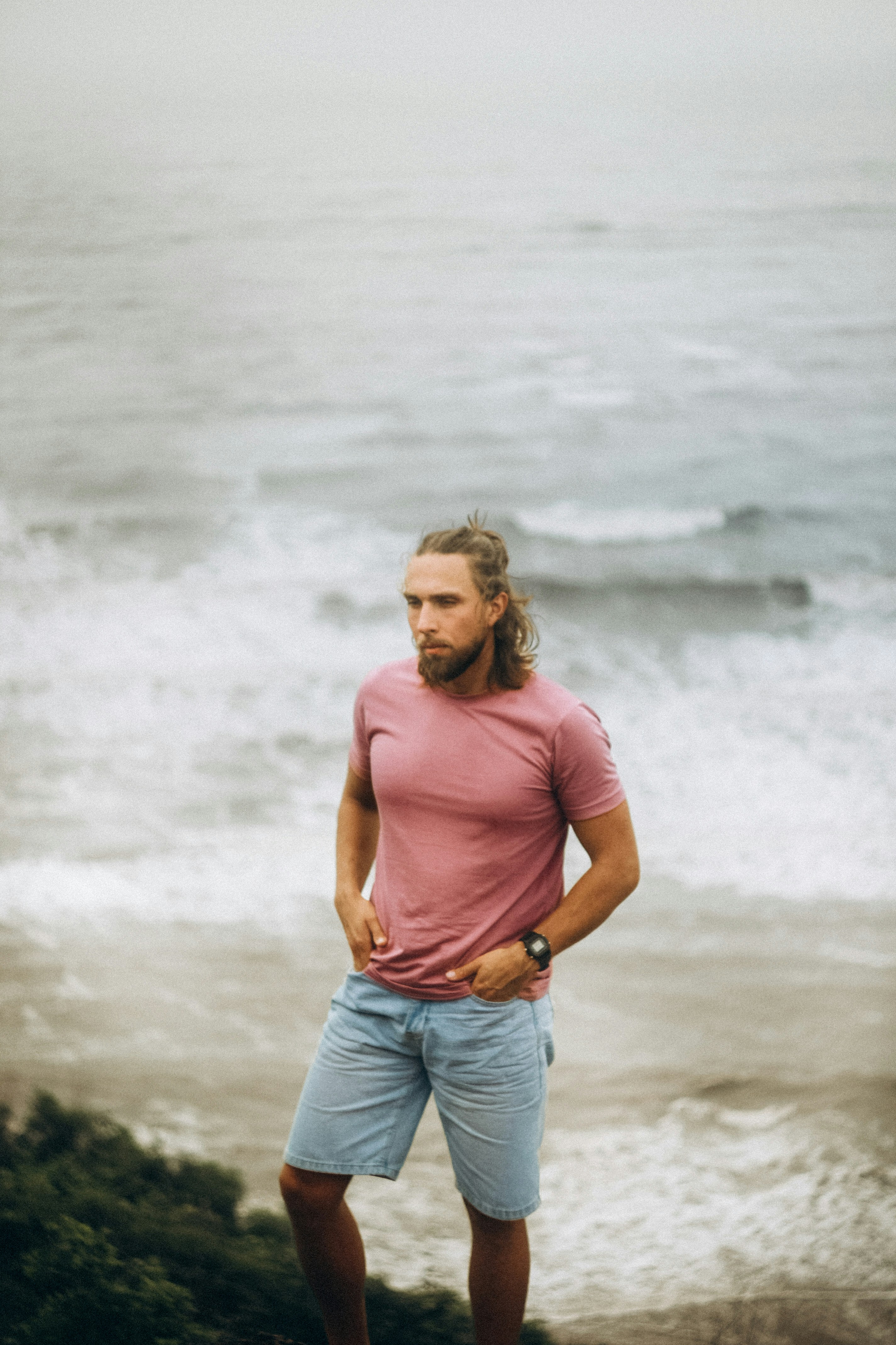 Man with beard and long hair by the ocean.