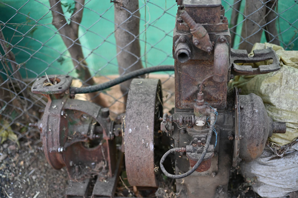 Rusty old engine with a large wheel.