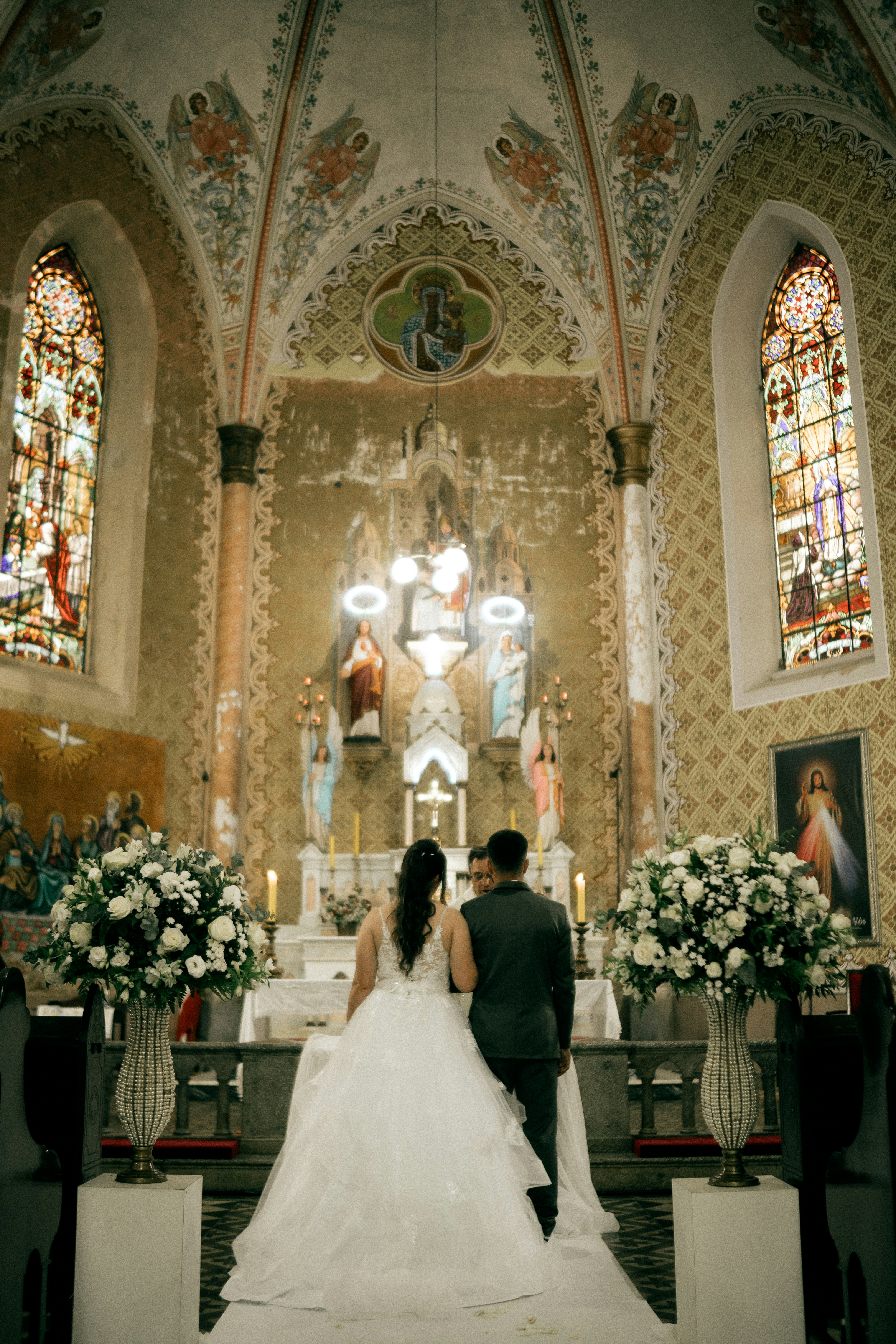 A wedding couple stands at the altar in a church.