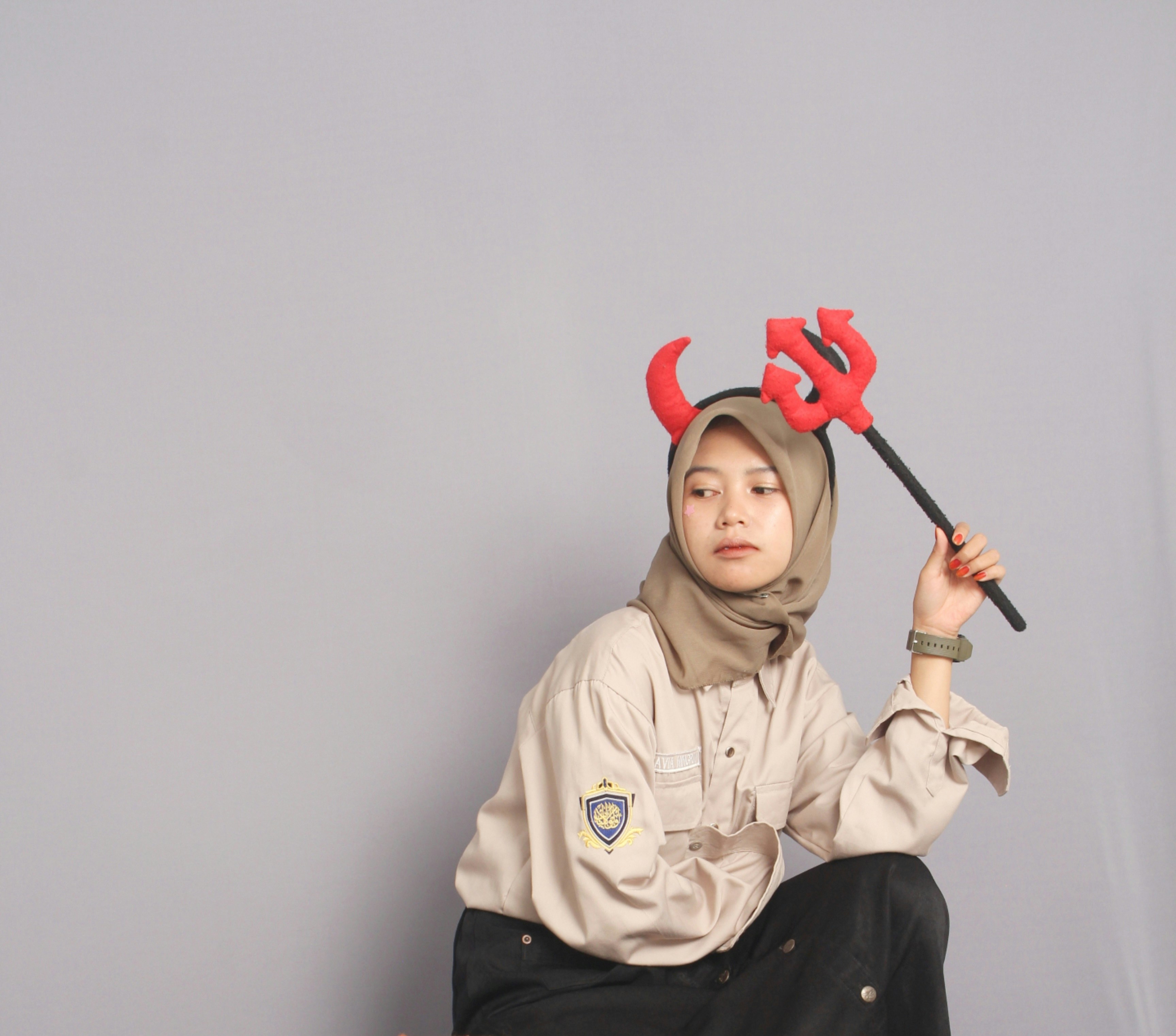 Woman in devil horns holding a trident