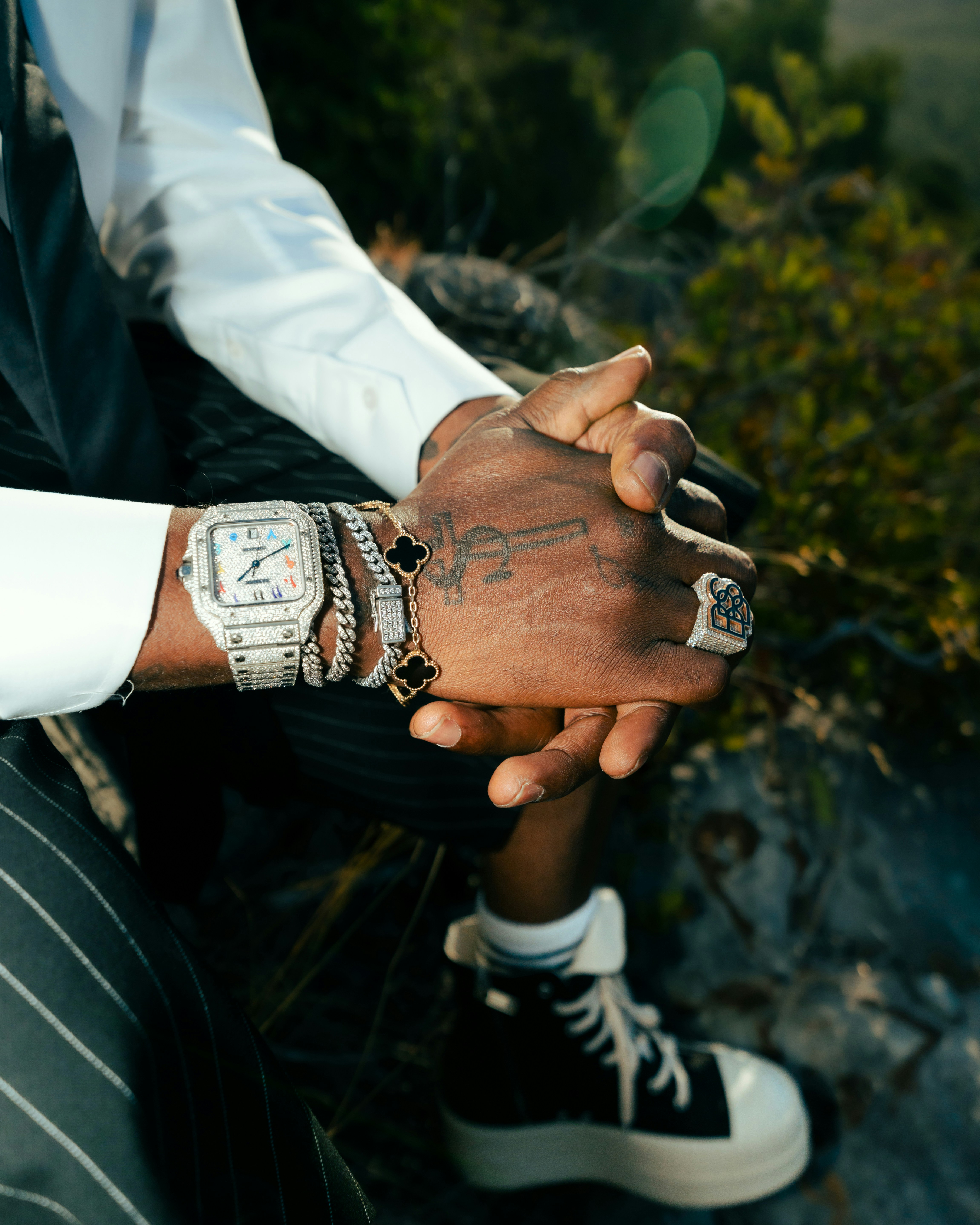 Man wearing jewelry and stylish sneakers outdoors