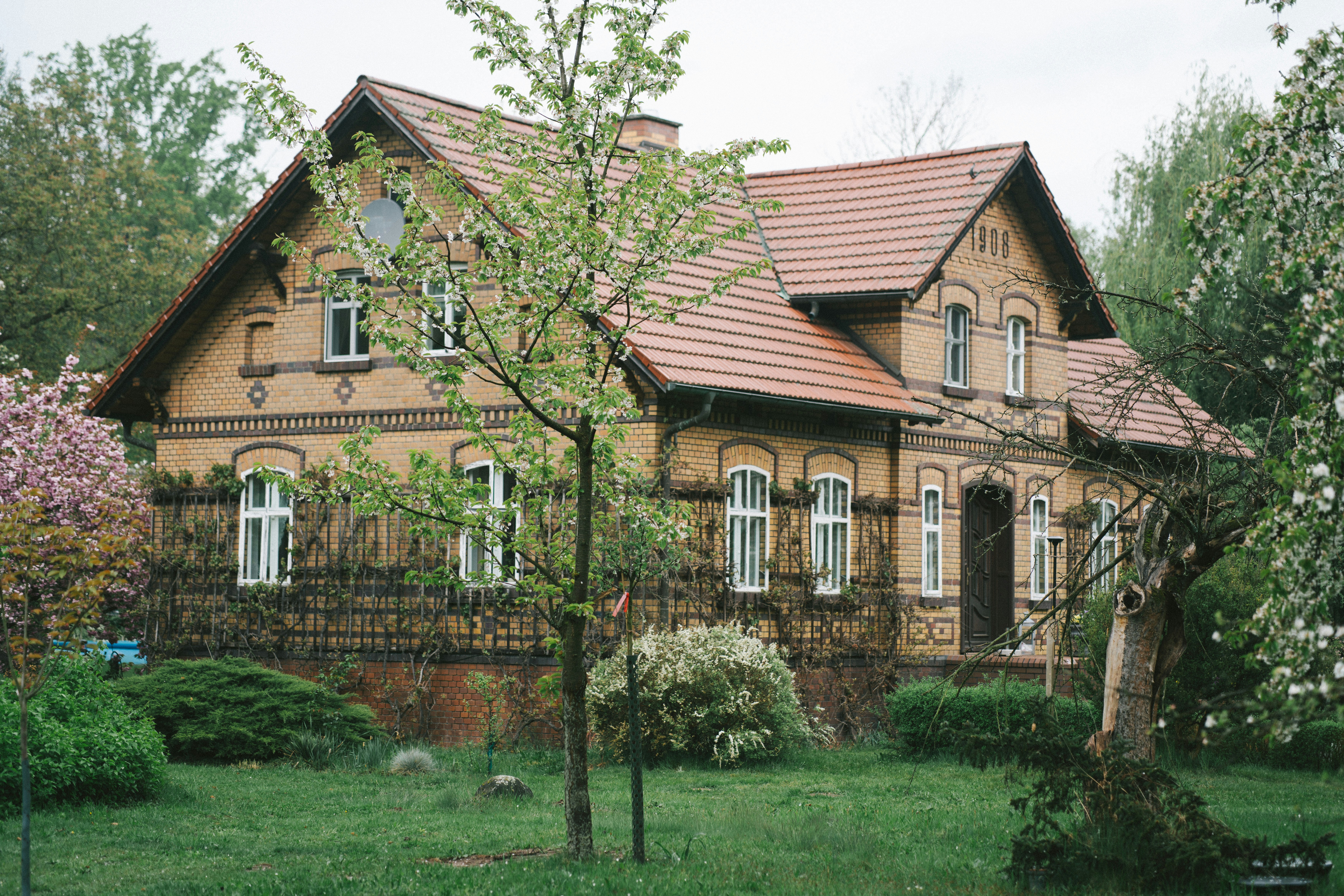 A charming brick house surrounded by lush greenery.