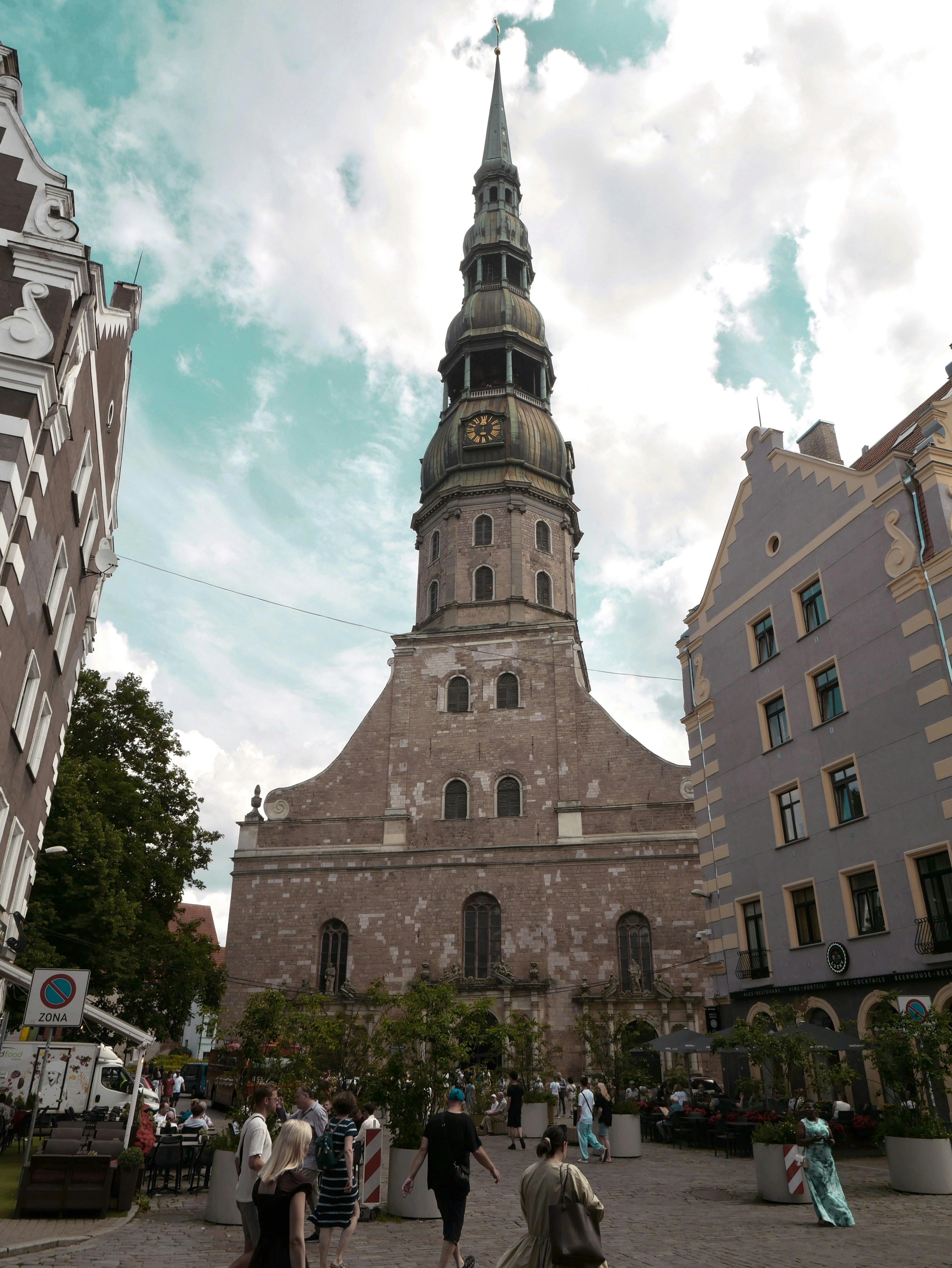 Historic church tower with clock in european city square.