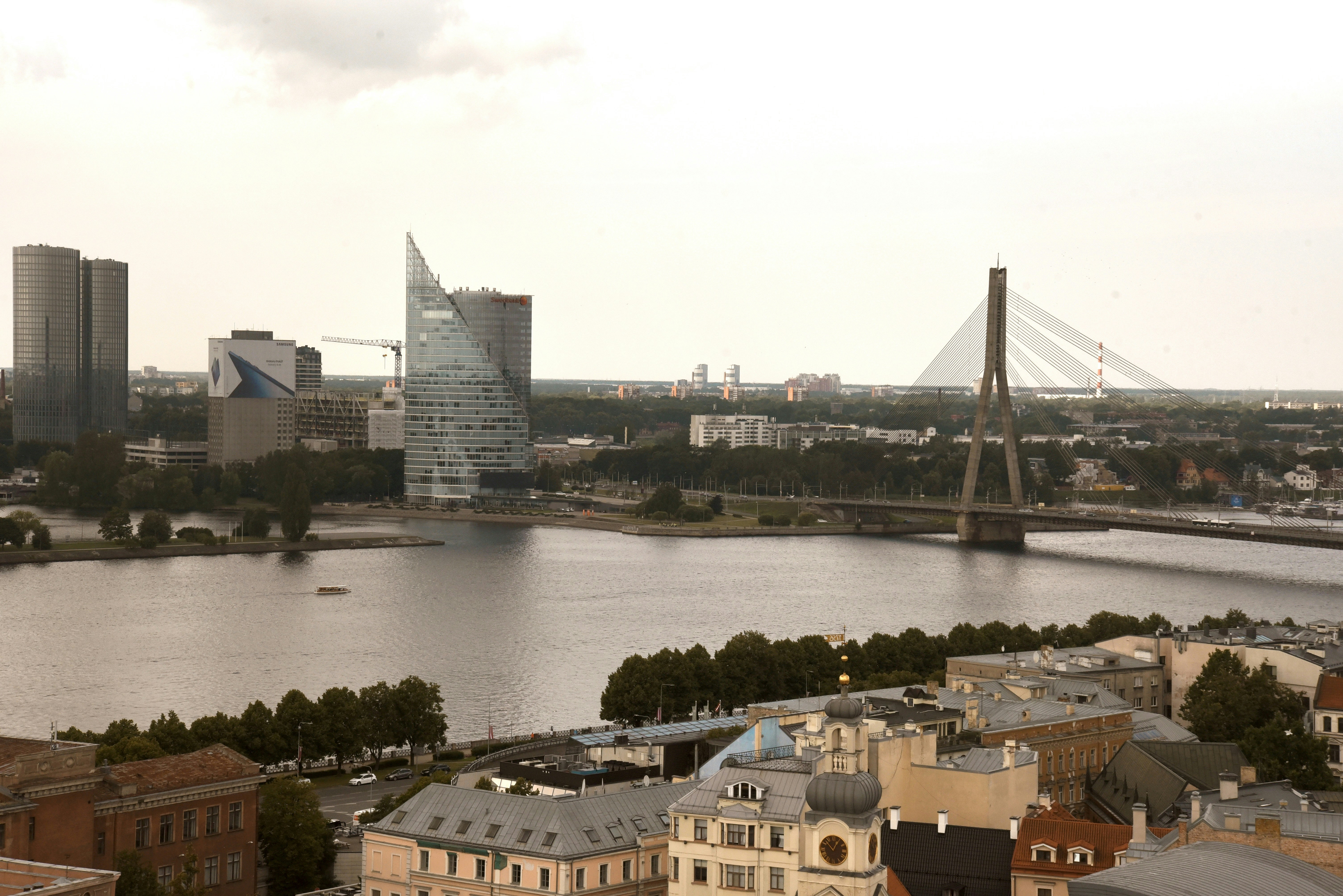 Cityscape with river and bridge under cloudy sky
