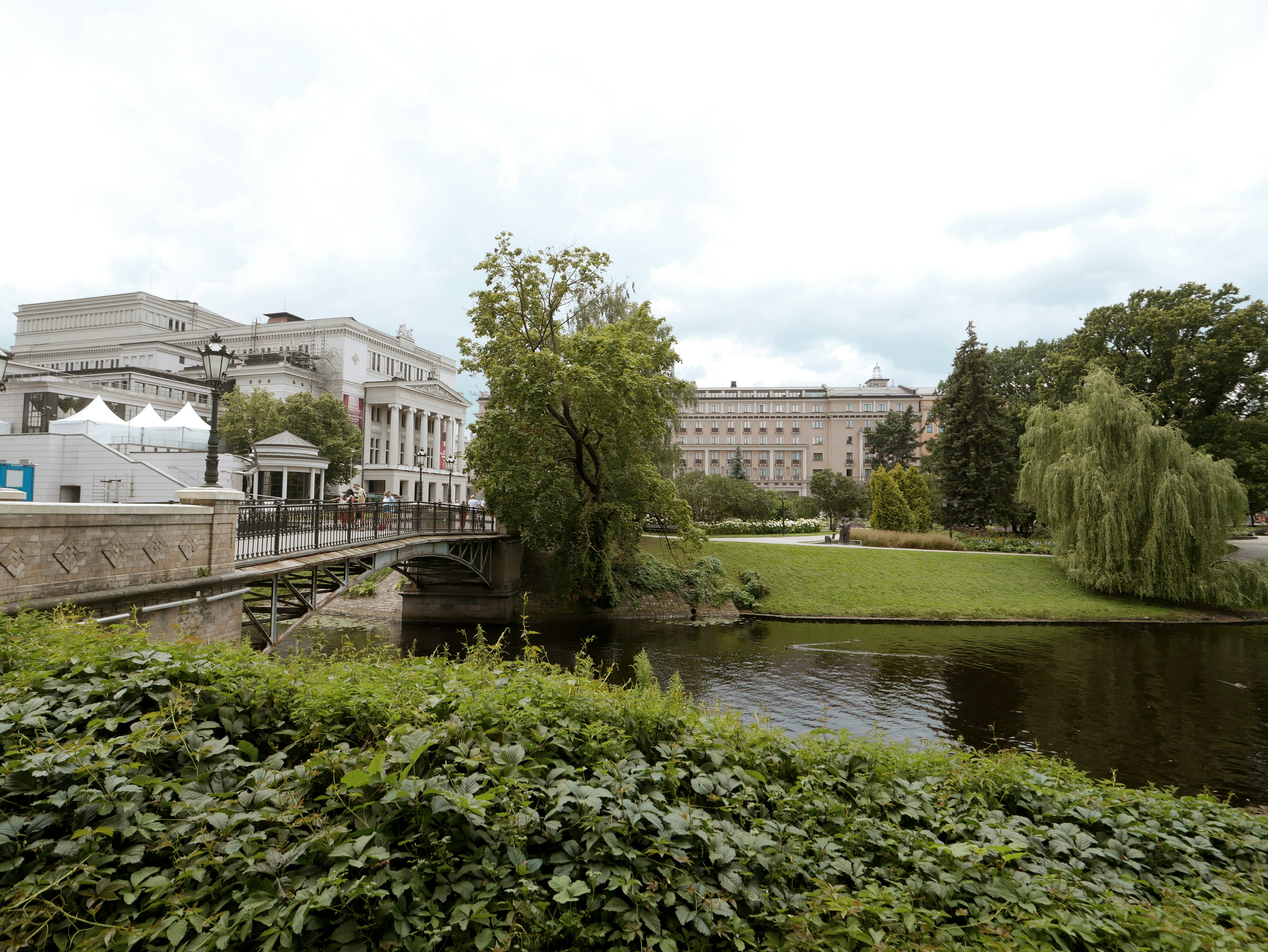 River flows past green park and buildings