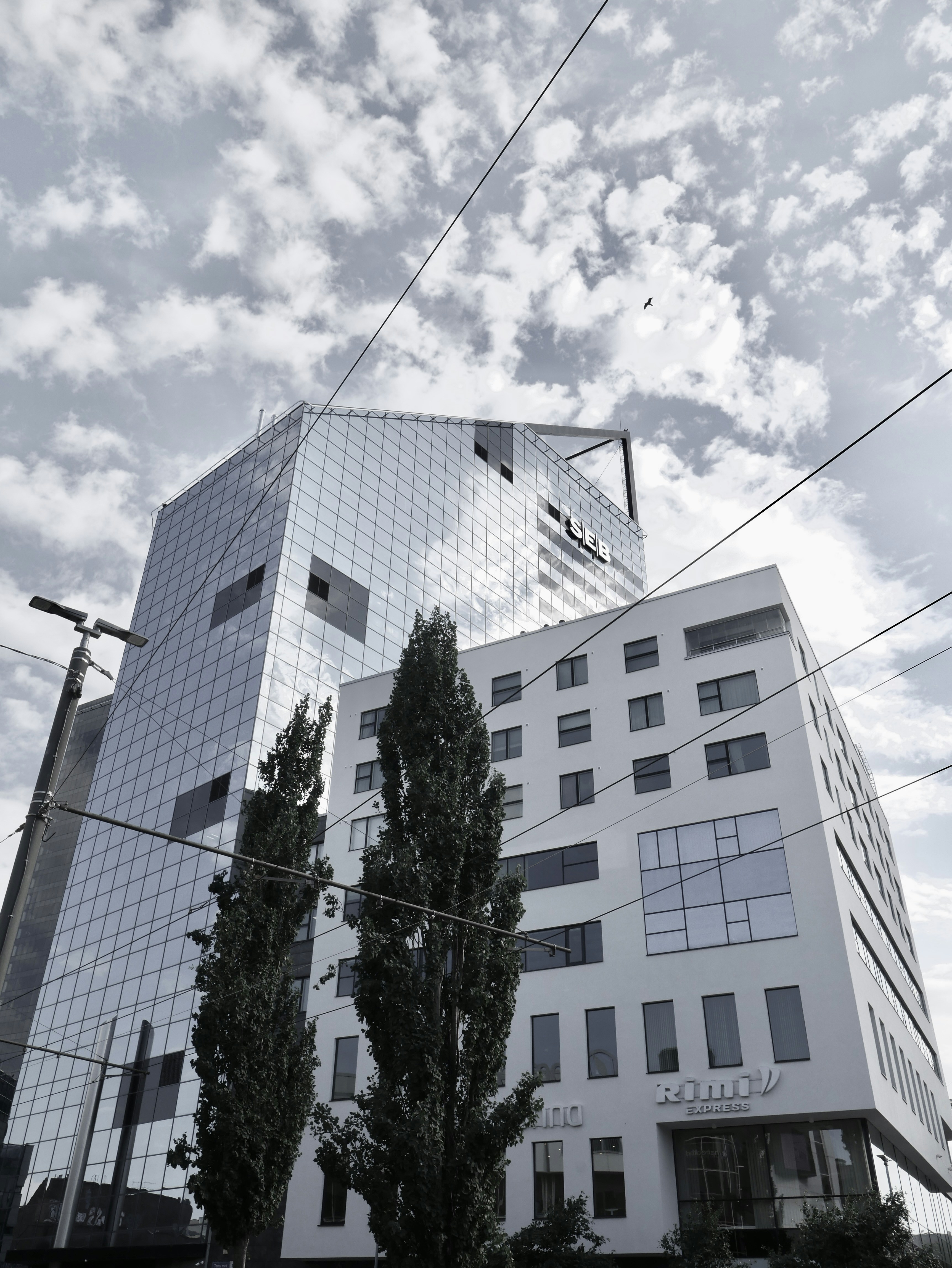 Modern glass buildings against a cloudy sky.