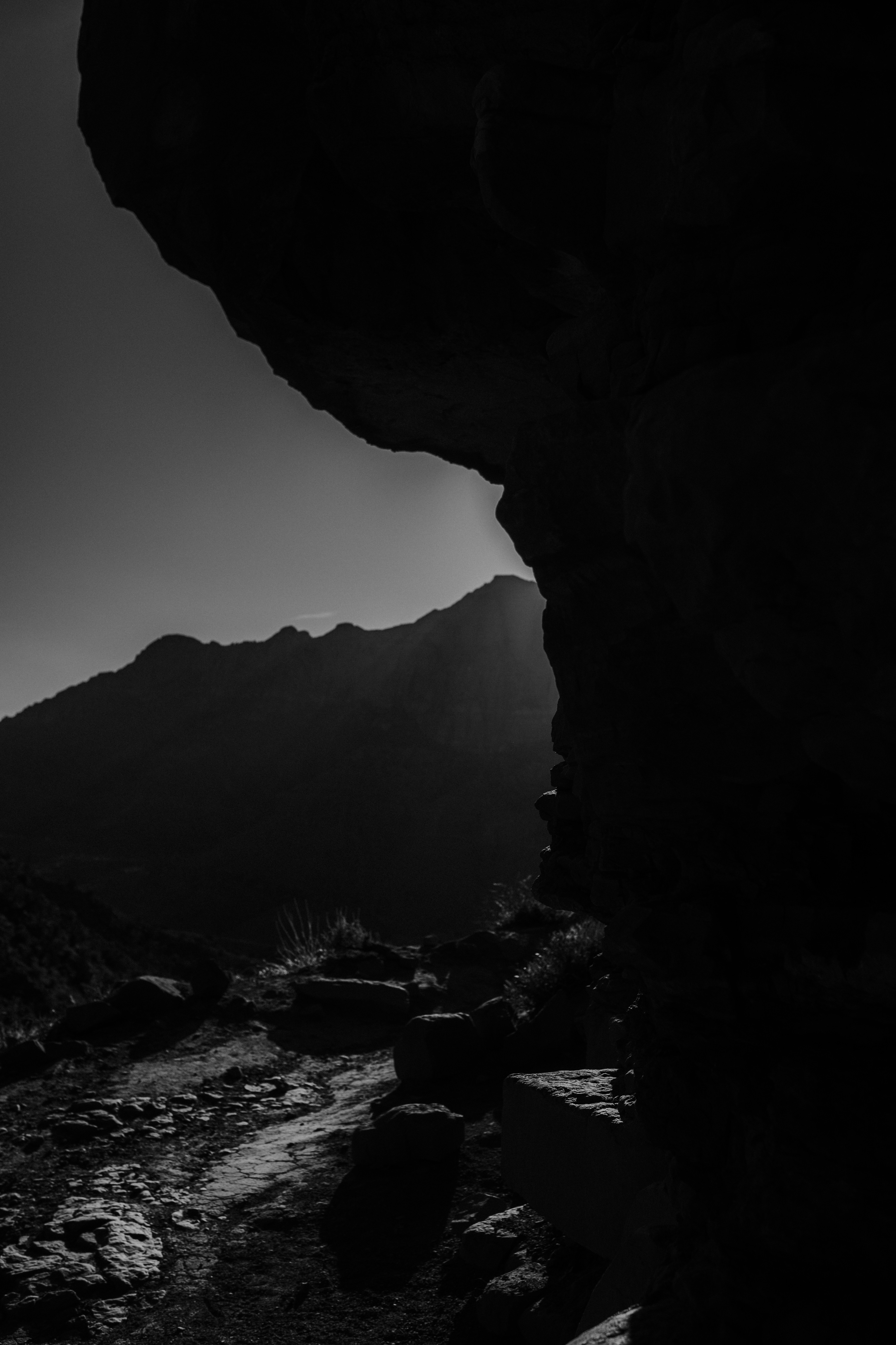 Rocky mountain path with sunlit peaks in background