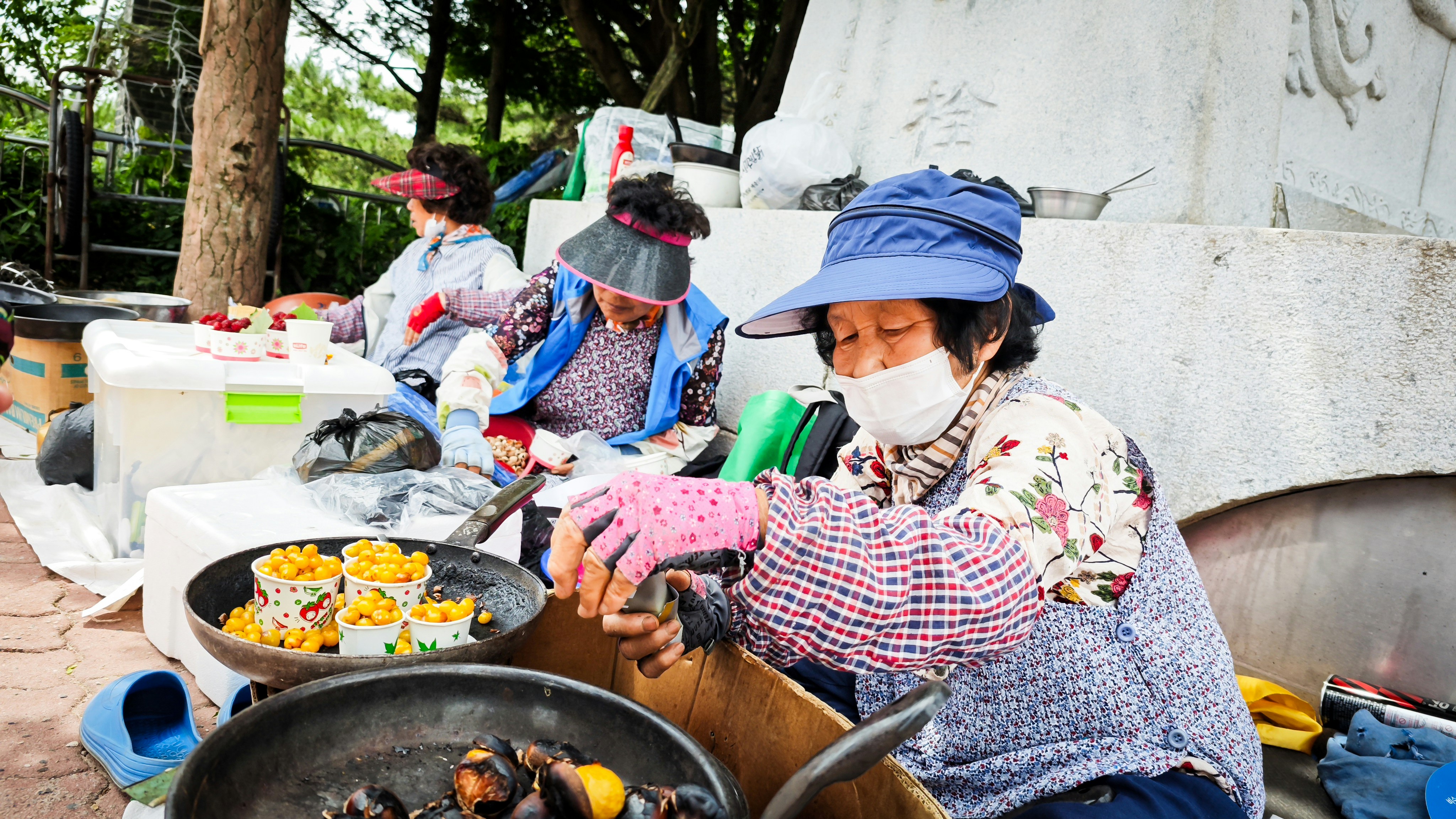 Women preparing food at an outdoor market stall