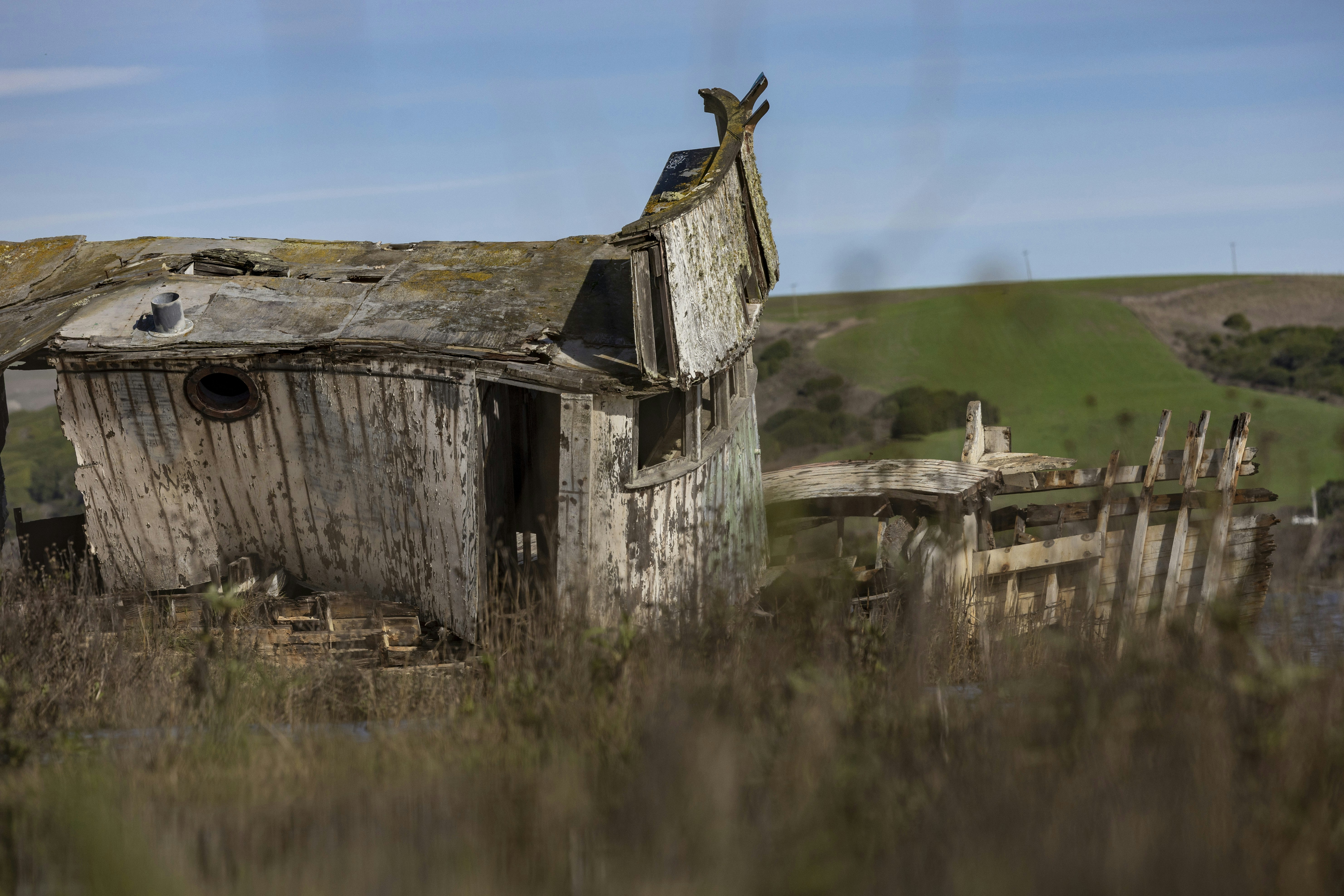 Ruined wooden structure on a grassy hill