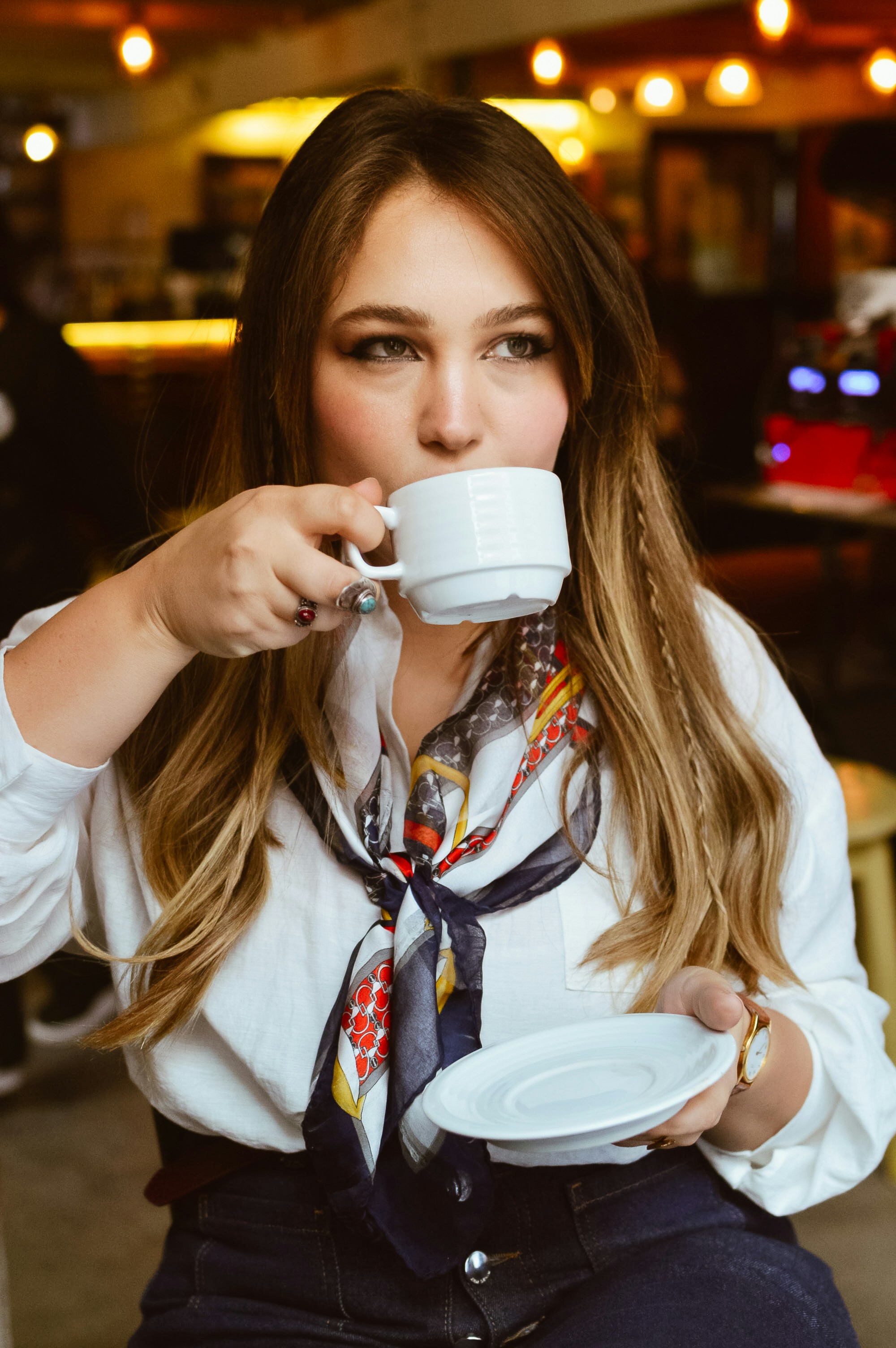 Uma mulher toma café em um café.