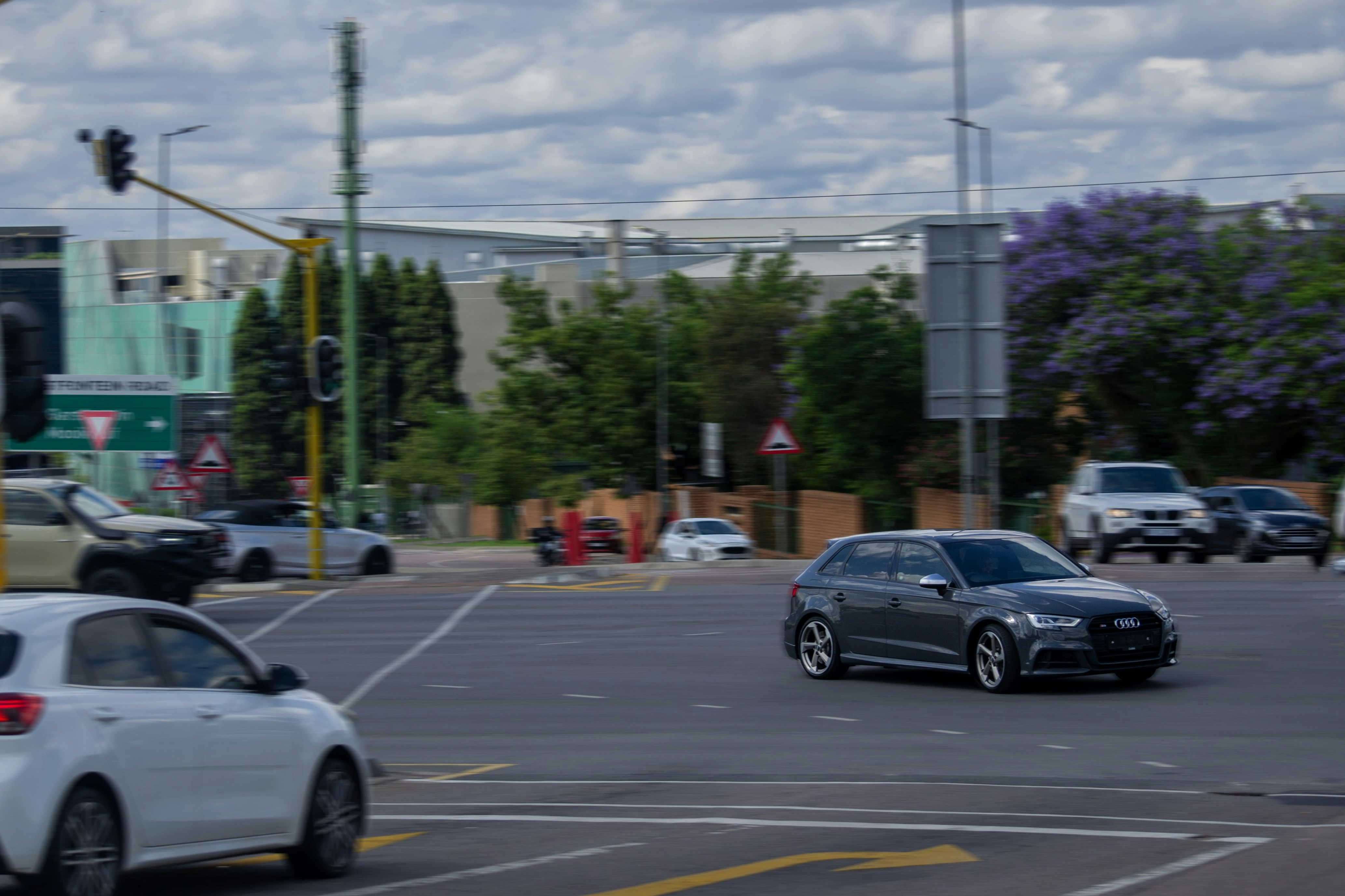 Cars at a busy city intersection with traffic lights