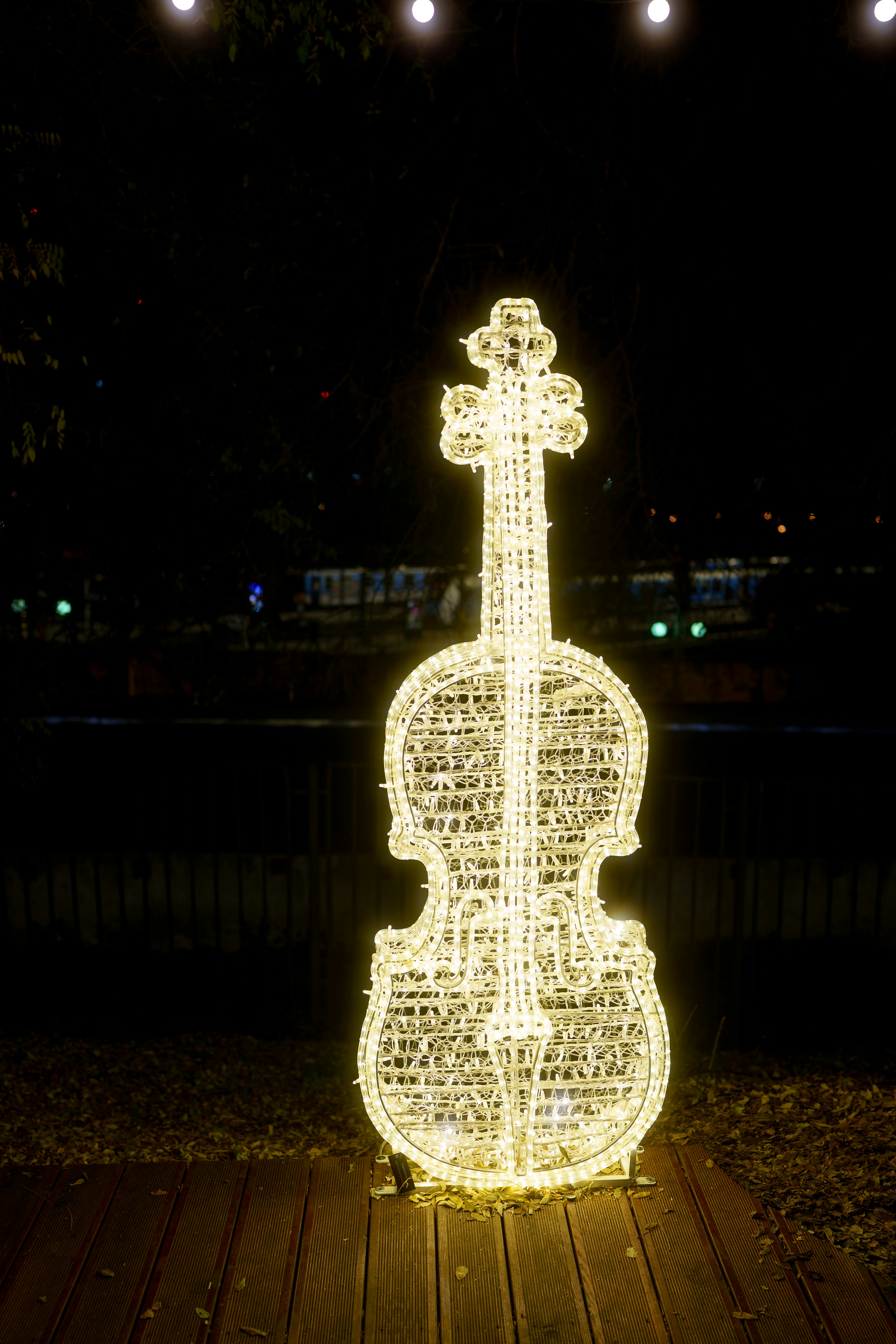 A large violin sculpture made of lights at night.