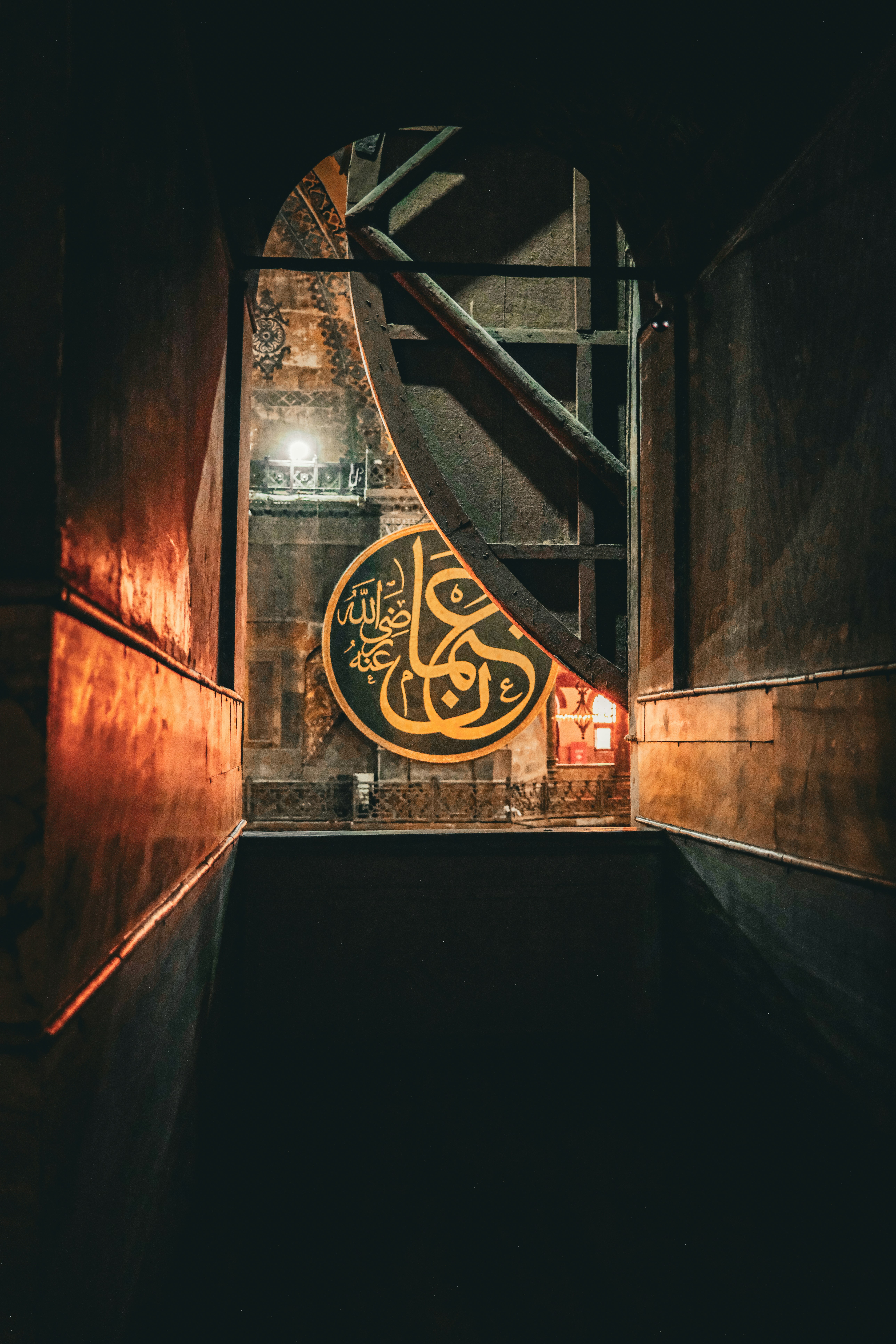 Ornate arabic calligraphy on a circular plaque.