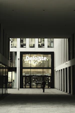 Man walks towards deloitte building entrance.