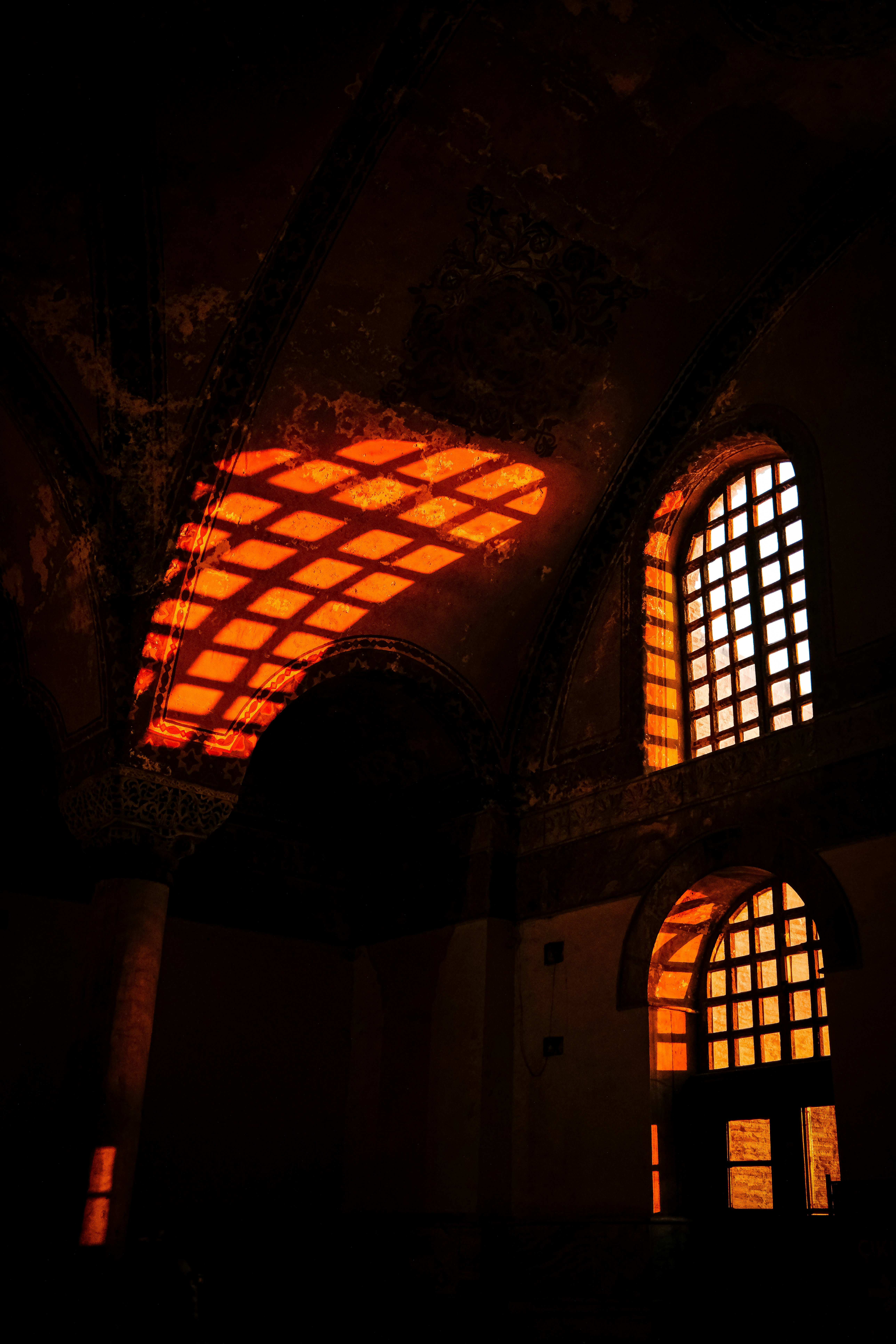 Orange light streams through arched windows